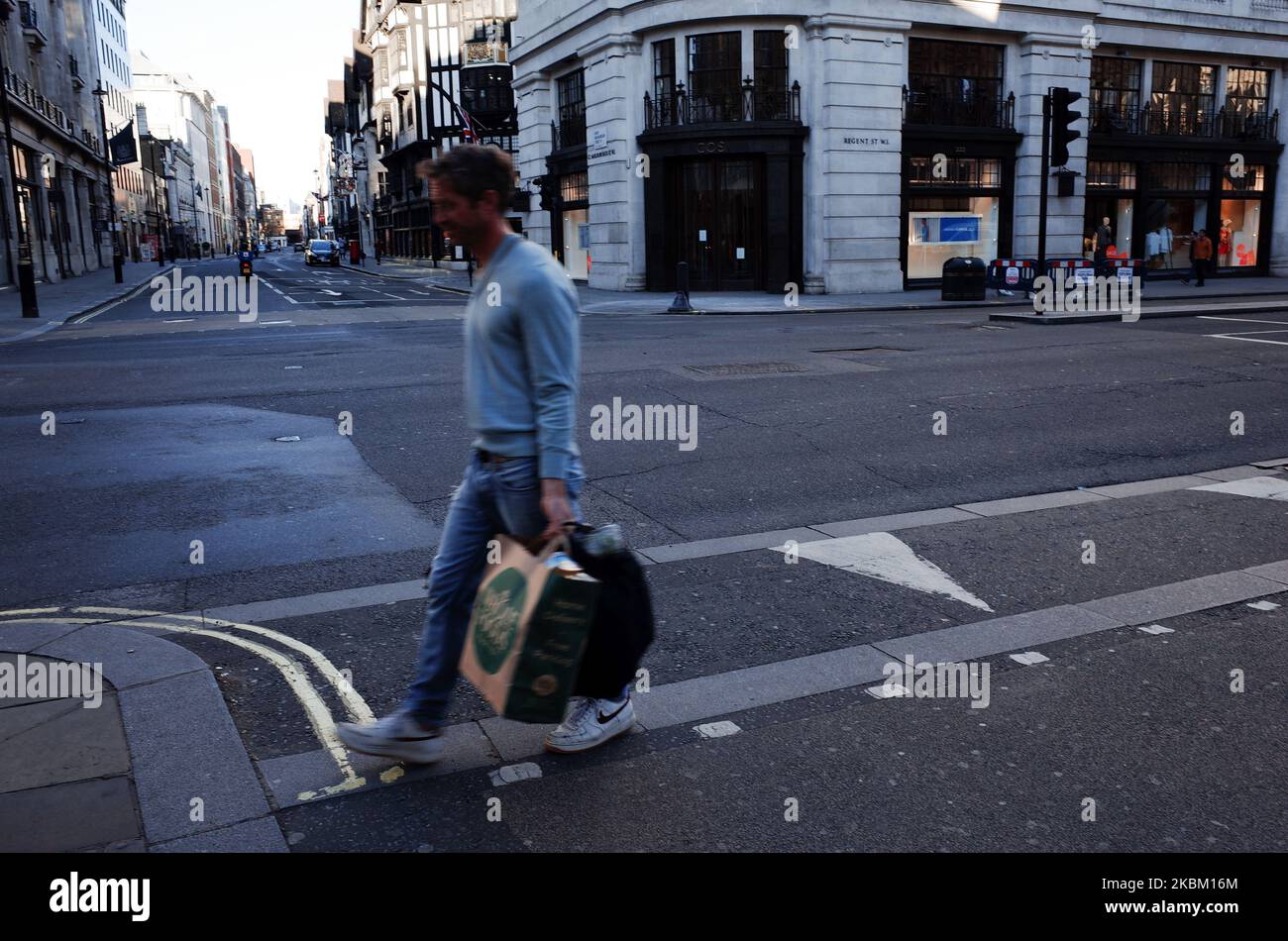 Am 4. April 2020 trägt ein Mann Tüten mit Lebensmitteleinkäufen entlang einer fast menschenleeren Regent Street in London, England. In ganz Großbritannien wurden bisher insgesamt 41.903 Fälle des Covid-19-Coronavirus bestätigt, wobei 4.313 Menschen starben. Das Land befindet sich mittlerweile fast zwei Wochen in seiner „Sperre“, die nach einer ersten dreiwöchigen Frist überprüft werden soll, obwohl eine Verlängerung weithin erwartet wird. Der britische Staatssekretär für Gesundheit und Soziales, Matt Hancock, bestand gestern darauf, dass die Regierung weiterhin darauf beharrte, dass Menschen zu Hause bleiben, um eine Verbreitung des Virus zu vermeiden Stockfoto