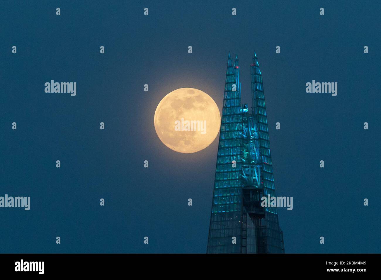 Am 07. April 2020 erhebt sich in London, England, ein Supermond, der auch als vollrosa Mond bezeichnet wird, über dem Zentrum Londons. Der April-Supermond ist der größte und hellste im Jahr 2020, da seine Umlaufbahn mit etwa 357.042 km in der nächsten Entfernung von der Erde liegt. (Foto: Wiktor Szymanowicz/NurPhoto) Stockfoto