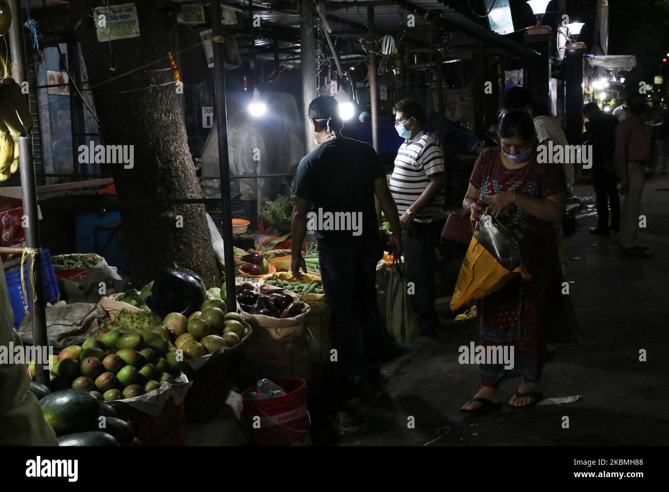 Die Menschen halten sichere Entfernungen aufrecht und kaufen Gemüse von einem Händler während einer Sperre in Kalkutta, Indien, am 17. April 2020. Der indische Premierminister Narendra Modi hat am Dienstag die weltweit größte Blockierung des Coronavirus verlängert, um den Höhepunkt der Epidemie zu erreichen, wobei Beamte rasten, um die verlorene Zeit aufzuholen. (Foto von Debajyoti Chakraborty/NurPhoto) Stockfoto