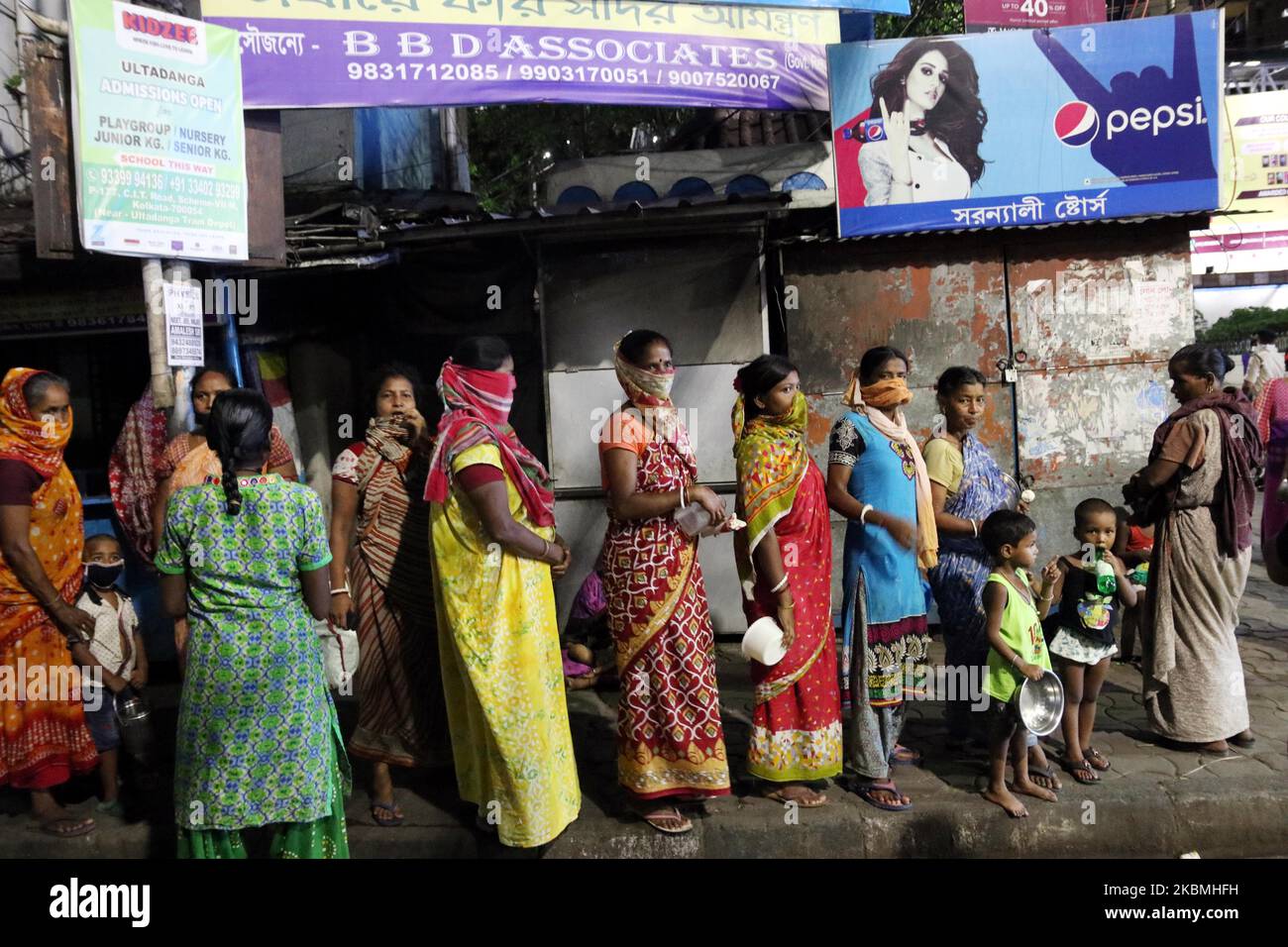 Slum-Leute warten in einer Schlange, um außerhalb des Bahnhofsbereichs kostenloses Essen zu erhalten, während sie am 17. April 2020 in Kalkutta, Indien, gesperrt wurden. Der indische Premierminister Narendra Modi hat am Dienstag die weltweit größte Blockierung des Coronavirus verlängert, um den Höhepunkt der Epidemie zu erreichen, wobei Beamte rasten, um die verlorene Zeit aufzuholen. (Foto von Debajyoti Chakraborty/NurPhoto) Stockfoto