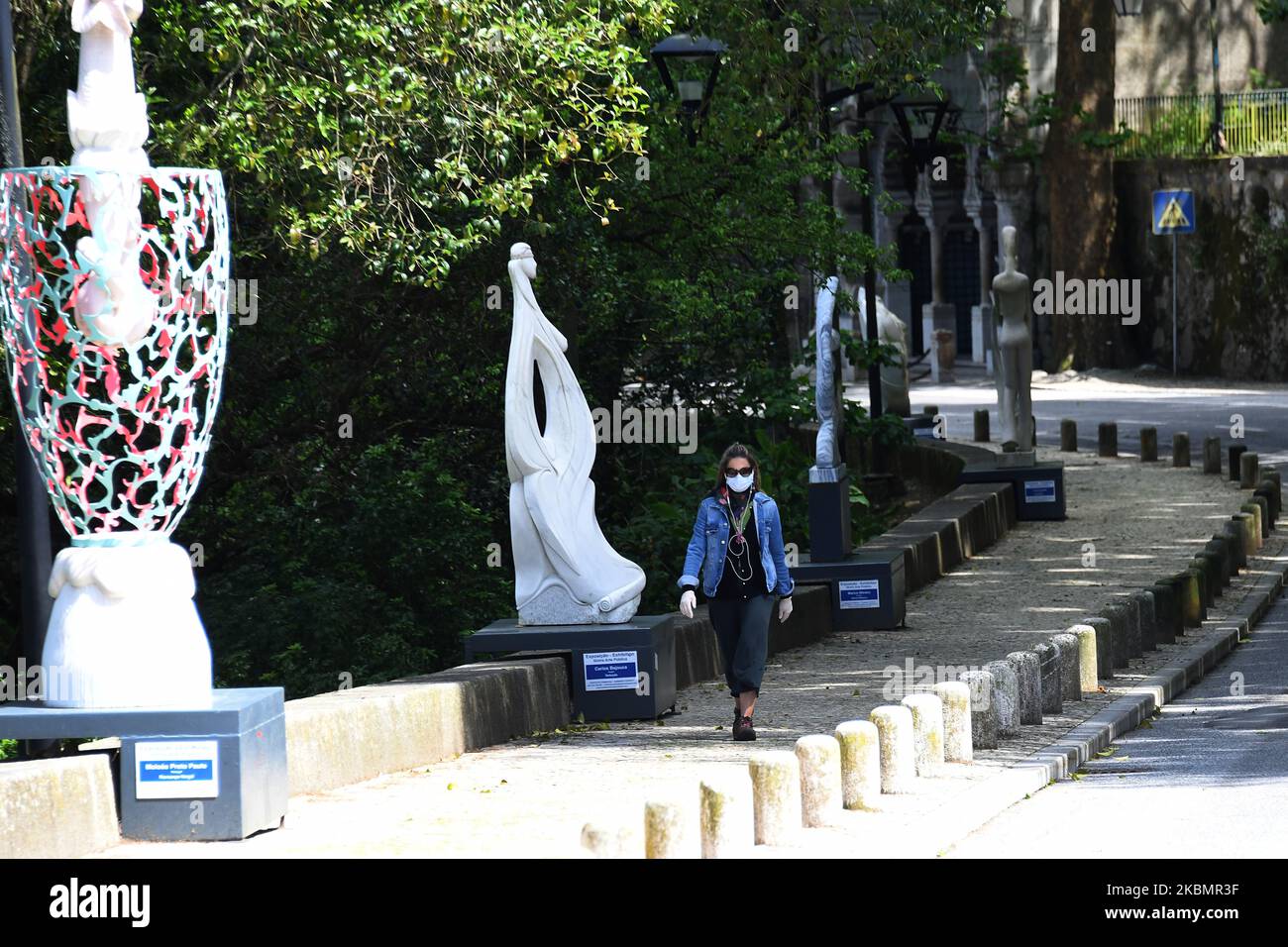 Eine Frau mit Schutzmaske geht durch den kulturellen Boulevard von Sintra, 22. April 2020. Die Verwüstung der COVID-19-Pandemie hat den Tourismus erschüttert, einer der wichtigsten Pfeiler der portugiesischen Wirtschaft. Die Pandemie hat den Tourismussektor „auf äußerst gewalttätige Weise“ angegriffen, so die Aussagen der politischen Führer der lusitanischen Nation. Die Arbeitsministerin gab bekannt, dass ihr Ministerium mehr als 1.400 Anträge auf vereinfachte Entlassung erhalten habe, die es Unternehmen ermöglichen, Arbeitsverträge auszusetzen oder die Arbeitszeit der Mitarbeiter zu reduzieren. (Foto von Jorge Mantilla/NurPhoto) Stockfoto
