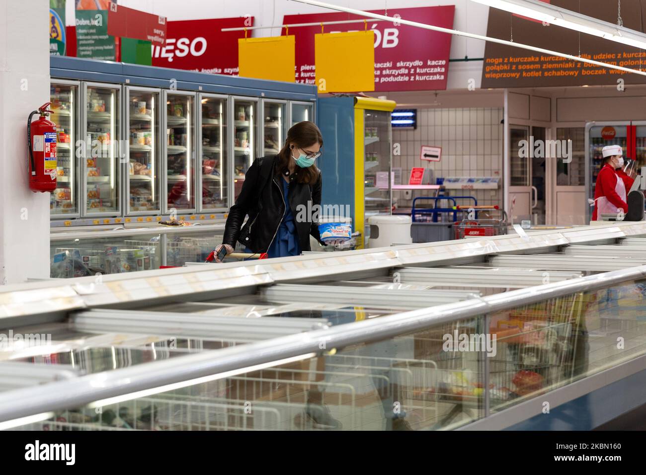 Eine Frau in einer schützenden Gesichtsmaske wird während der ersten Tage einer leichten Lockdown während der Covid-19-Pandemie in Krakau, Polen, am 27. April 2020 beim Einkaufen im Auchan-Supermarkt gesehen. Nach wenigen Wochen strenger Lockdown entspannt sich die Politik, aber die Polen müssen immer noch Abstand halten und in der Öffentlichkeit zu jeder Zeit Schutzmasken tragen. (Foto von Dominika Zarzycka/NurPhoto) Stockfoto