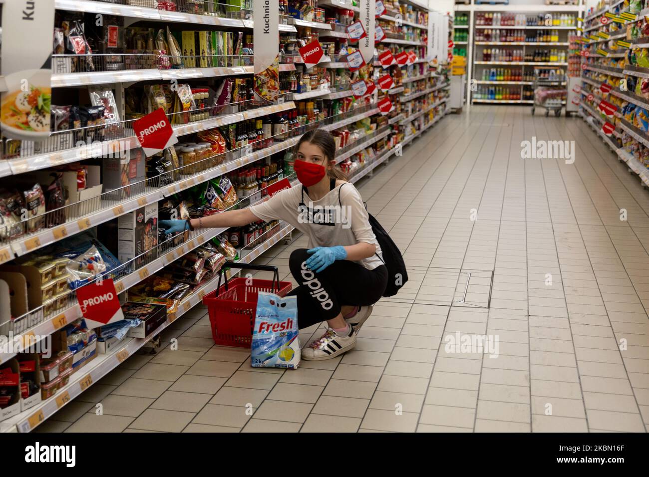 Eine Frau in einer schützenden Gesichtsmaske wird während der ersten Tage einer leichten Lockdown während der Covid-19-Pandemie in Krakau, Polen, am 27. April 2020 beim Einkaufen im Auchan-Supermarkt gesehen. Nach wenigen Wochen strenger Lockdown entspannt sich die Politik, aber die Polen müssen immer noch Abstand halten und in der Öffentlichkeit zu jeder Zeit Schutzmasken tragen. (Foto von Dominika Zarzycka/NurPhoto) Stockfoto