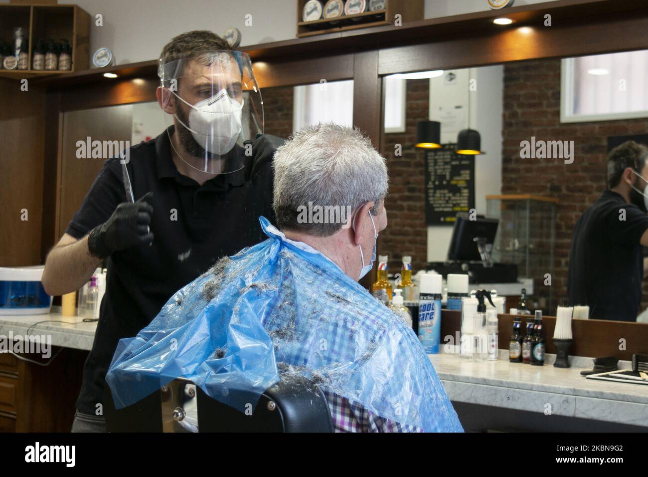 Ein Mann bekommt einen Haarschnitt bei einem Friseur, als das Land am 4. Mai 2020 in Madrid, Spanien, offiziell die erste von vier Phasen der Deeskalation einleitet. Da Spanien die akute Phase der Krankheit verblassen sieht, beginnt am Montag offiziell die erste von vier Phasen der Deeskalation. Einige Unternehmen wie Friseure, Zahnärzte oder Eisenwarengeschäfte beginnen zu operieren, aber Kunden werden nur nach Vereinbarung zugelassen. (Foto von Oscar Gonzalez/NurPhoto) Stockfoto