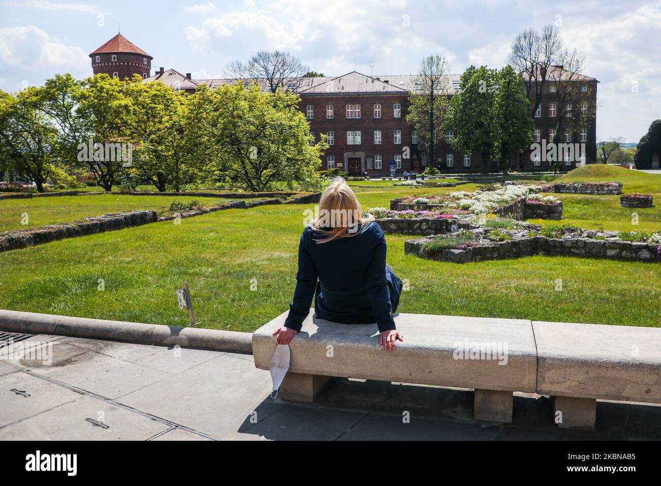 Eine Frau entspannt sich beim Besuch des Wawel-Hügels, der nach der Schließung im März aufgrund der Ausbreitung des Coronavirus wieder geöffnet wurde. Krakau, Polen, am 4.. Mai 2020. In der ersten Phase der Wiedereröffnung des Königsschlosses Wawel sind Besucher in den Außenbereichen willkommen - dem Arkadenhof, dem Außenhof und den königlichen Gärten. (Foto von Beata Zawrzel/NurPhoto) Stockfoto