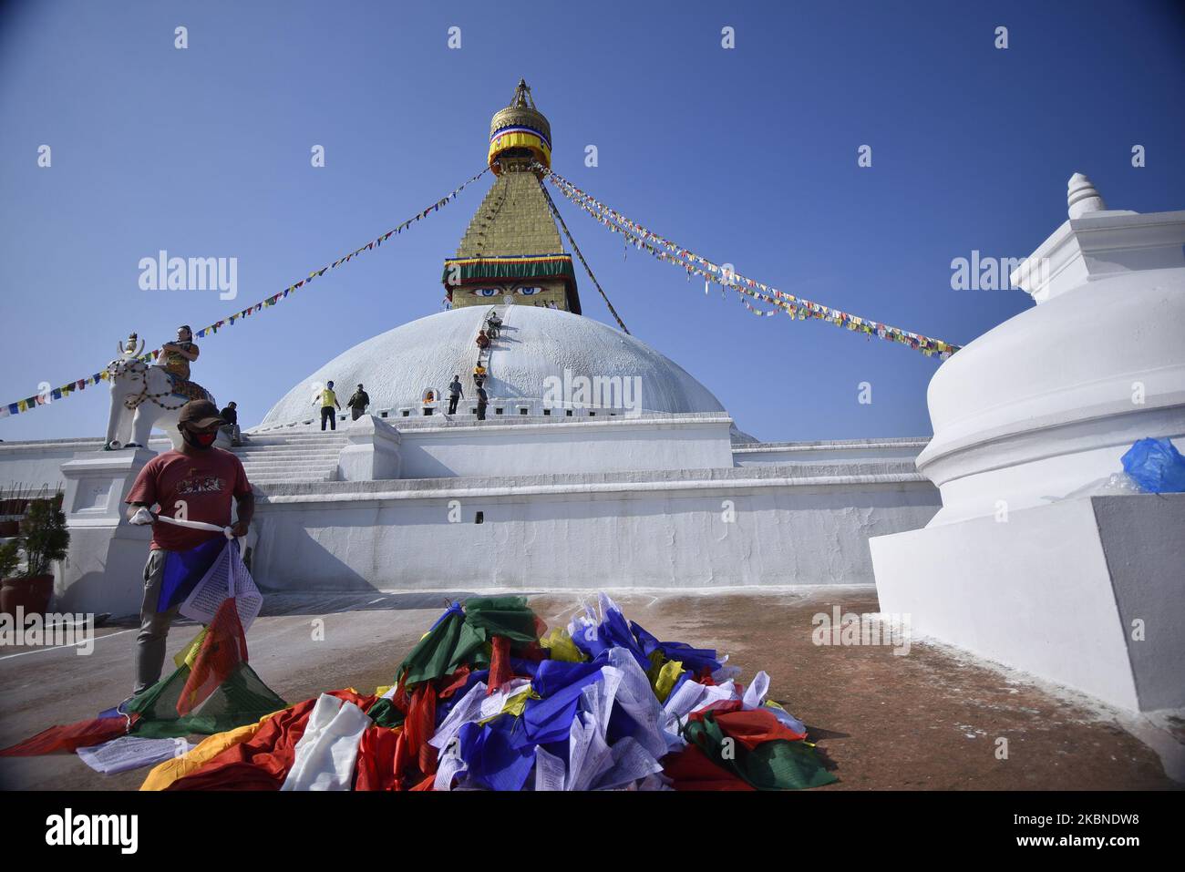 Ein nepalesischer buddhistischer Anhänger arrangiert Gebetsfahne, um Boudhanath Stupa, ein UNESCO-Weltkulturerbe, zu schmücken, während der Feier des Buddha-Purnima-Festes 2.564, des Geburtstages von Lord Gautam Buddha, feierte während der landesweiten Sperrung als Besorgnis über die Ausbreitung des Corona-Virus (COVID-19) in Kathmandu, Nepal, am Donnerstag, den 07. Mai 2020. Buddhisten auf der ganzen Welt, Kambodscha; Thailand; Myanmar; Bhutan; Sri Lanka; Laos; Mongolei; Japan; Singapur; Taiwan einschließlich Nepal, beobachten Sie das Buddha Purnima Festival, das auf den gleichen Tag des Vollmonds des Monats-Kalenders fällt. (Foto von Narayan Maharjan Stockfoto