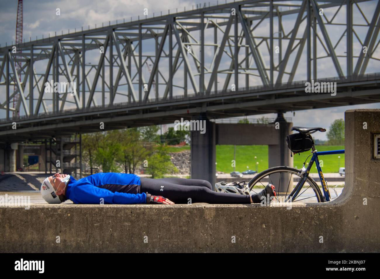 Ein Radfahrer ruht sich auf den Stufen des Ohio River im Gefolge der Coronavirus COVID-19 Pandemie am 6. Mai 2020 in Cincinnati, Ohio, Usa. (Foto von Jason Whitman/NurPhoto) Stockfoto