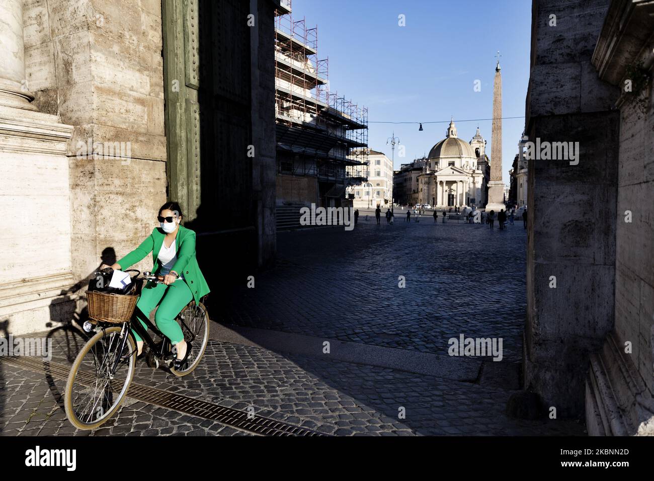 Eine Frau, die während der ‘Fase 2’ (Phase 2) in Roma nach der Sperre des Landes aufgrund des Covid-19-Ausbruchs auf der Piazza del Popolo radelt, Roma, 12.. Mai, Italien. (Foto von Matteo Trevisan/NurPhoto) Stockfoto