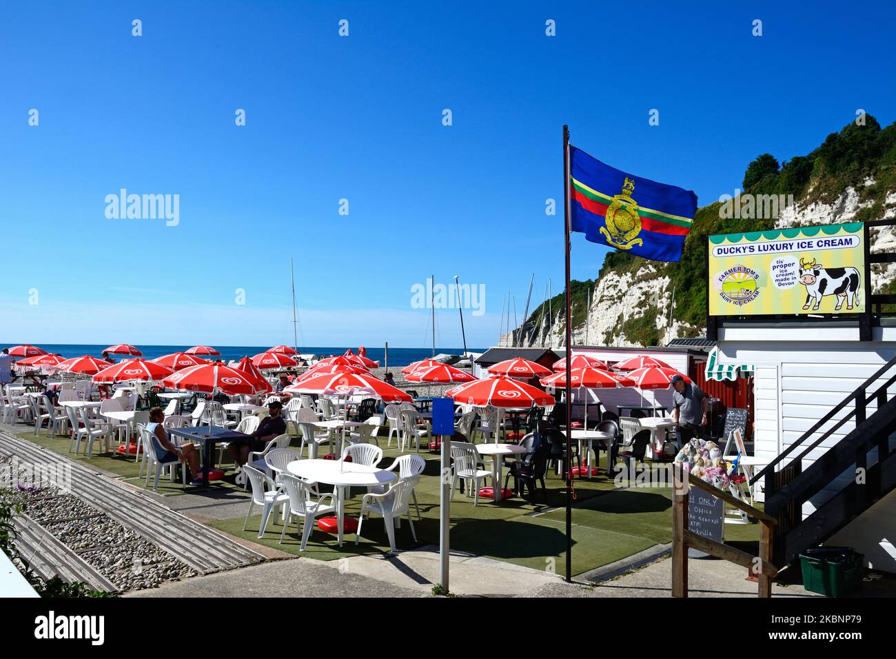 Cafe am Strand mit Lyme Bay Strand und Klippen nach hinten, Bier, Devon, Großbritannien, Europa. Stockfoto