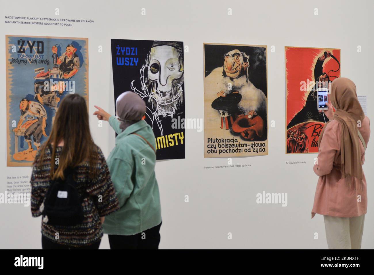 Die Besucher sehen sich antisemitische Nazi-Plakate an, die an Polen gerichtet sind, die Teil des Zweiten Weltkriegs – Drama, Symbol, Trauma-Ausstellung im Museum für zeitgenössische Kunst MOCAK in Krakau sind. Am 16. Mai 2020 in Krakau, Polen. (Foto von Artur Widak/NurPhoto) Stockfoto