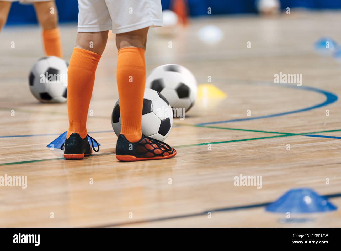 Fußball Wintersaison Training für Kinder. Infoor Fußball-Übungsklasse für Schulkinder. Beine des Fußballjungen mit Ball Stockfoto