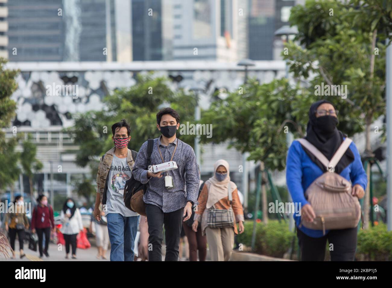 Menschen tragen Schutzmasken, als sie die Straße in Jakarta überqueren, 19. Mai 2020. Die indonesische Hauptstadt Jakarta, die am stärksten vom COVID-19-Ausbruch betroffen ist, beschloss am Dienstag, den 19. Mai, eine teilweise Sperrung erneut zu verlängern, da die Zahl der Virusinfektionen im Land ansteigt. Jakartas Gouverneurin Anies Baswedan kündigte an, dass die teilweise Sperrung um weitere 14 Tage bis zum 4. Juni verlängert wird. Der Gouverneur der Stadt forderte die Bürger auf, die Regeln zur Beschränkung der Ausbreitung des Virus in der Hauptstadt von über 10 Millionen Menschen zu befolgen. (Foto von Afriadi Hikmal/NurPhoto) Stockfoto