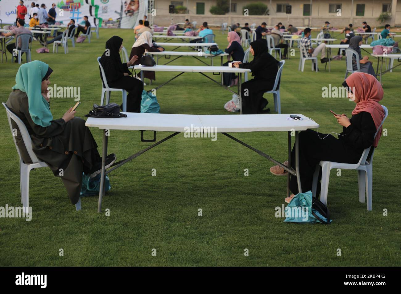 Palästinenser, die eine Maske tragen, während sie darauf warten, ihre Fast-Meal-Einrichtung zu brechen, um die sozialen Distanzierungsmaßnahmen zu respektieren, die im Rahmen der Pandemie COVID-19, die von der islamischen Hamas-Bewegung, die den belagerten Gazastreifen führt, am 21. Mai 2020 im palästinensischen Fußballstadion in Gaza-Stadt organisiert wurde, Vor dem Start einer digitalen Kampagne zum internationalen Tag von al-Quds (Jerusalem). (Foto von Majdi Fathi/NurPhoto) Stockfoto