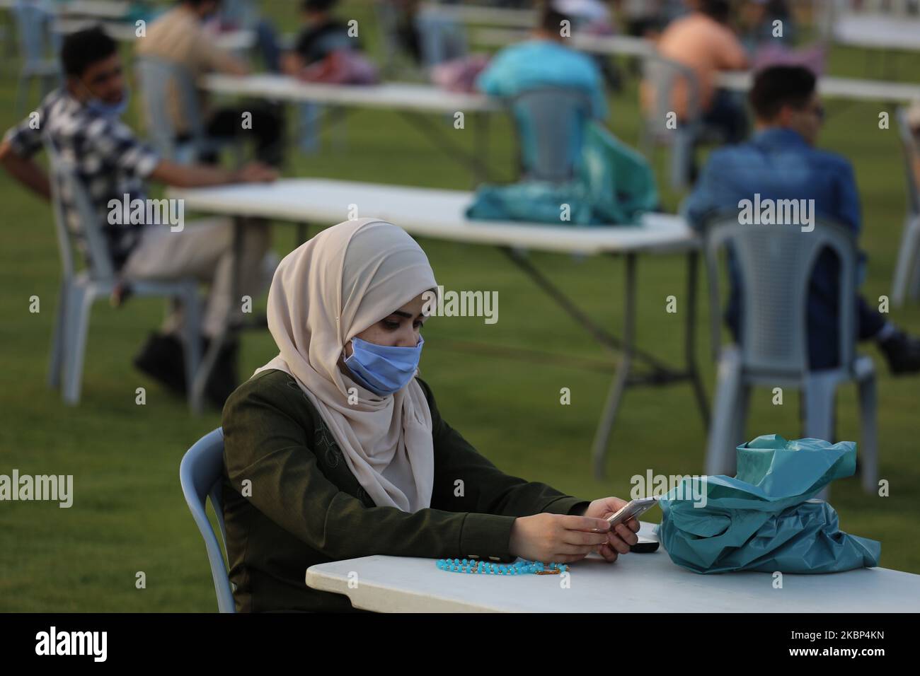 Palästinenser, die eine Maske tragen, während sie darauf warten, ihre Fast-Meal-Einrichtung zu brechen, um die sozialen Distanzierungsmaßnahmen zu respektieren, die im Rahmen der Pandemie COVID-19, die von der islamischen Hamas-Bewegung, die den belagerten Gazastreifen führt, am 21. Mai 2020 im palästinensischen Fußballstadion in Gaza-Stadt organisiert wurde, Vor dem Start einer digitalen Kampagne zum internationalen Tag von al-Quds (Jerusalem). (Foto von Majdi Fathi/NurPhoto) Stockfoto