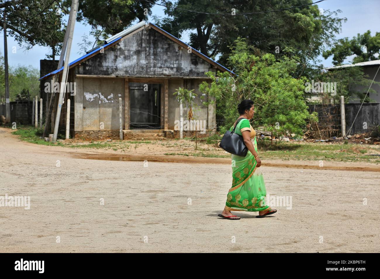 Frau kommt am 14. August 2017 in Keerimalai, Jaffna, Sri Lanka, an Häusern vorbei, die durch Bombenangriffe zerstört wurden. Dies ist nur eine der vielen Erinnerungen an die tiefen Narben, die während des 26-jährigen Bürgerkrieges zwischen der srilankischen Armee und der LTTE (Liberation Tigers of Tamil Eelam) entstanden sind. Die Vereinten Nationen schätzen, dass während des Krieges etwa 40.000 Menschen getötet wurden. (Foto von Creative Touch Imaging Ltd./NurPhoto) Stockfoto