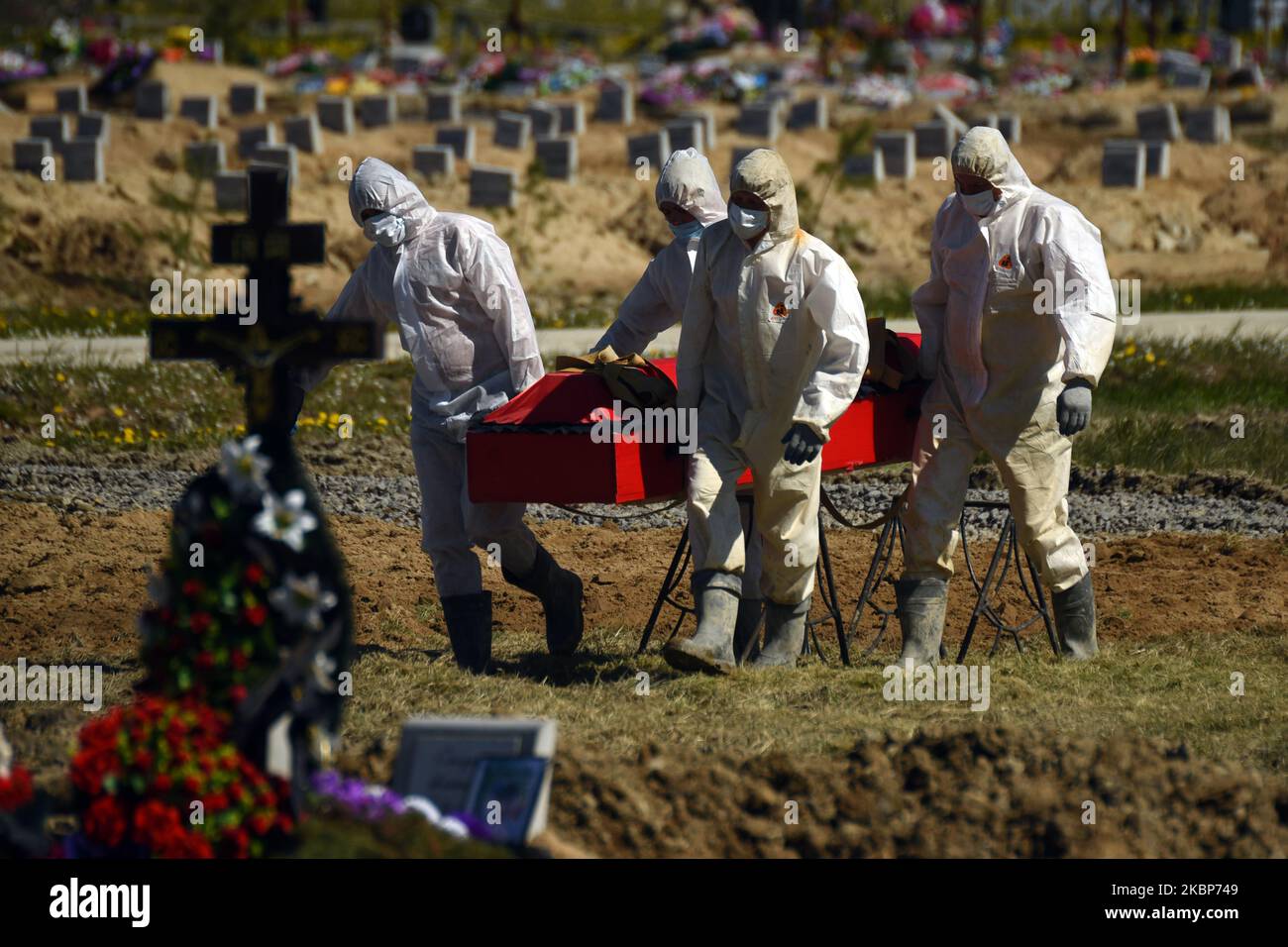 Friedhofsmitarbeiter in chemischen Schutzanzügen, die einen Sarg bei der Beerdigung der COVID-19-Opfer in Kolpino, außerhalb von St. Petersburg, Russland, am 23. Mai 2020 trugen. (Foto von Sergey Nikolaev/NurPhoto) Stockfoto