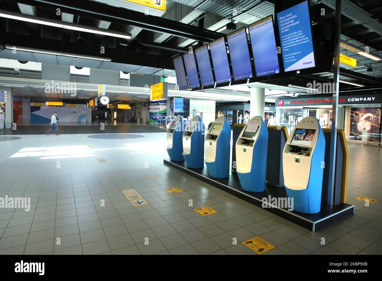 Während der Coronavirus-Pandemie am 26. Mai 2020 in Amsterdam, Niederlande, ist auf den leeren automatischen Check-in-Automaten am Flughafen Schiphol ein Mann-Pass in der Nähe von Monitoren mit Ausflugsinformationen zu sehen. KLM warnte davor, dass die Nachfrage nach Flugreisen mehrere Jahre dauern wird, um sich zu erholen und die Verwüstung, die die Luftfahrtindustrie durch die Coronavirus-Pandemie ausübt, zu verhmmern. (Foto von Paulo Amorim/NurPhoto) Stockfoto