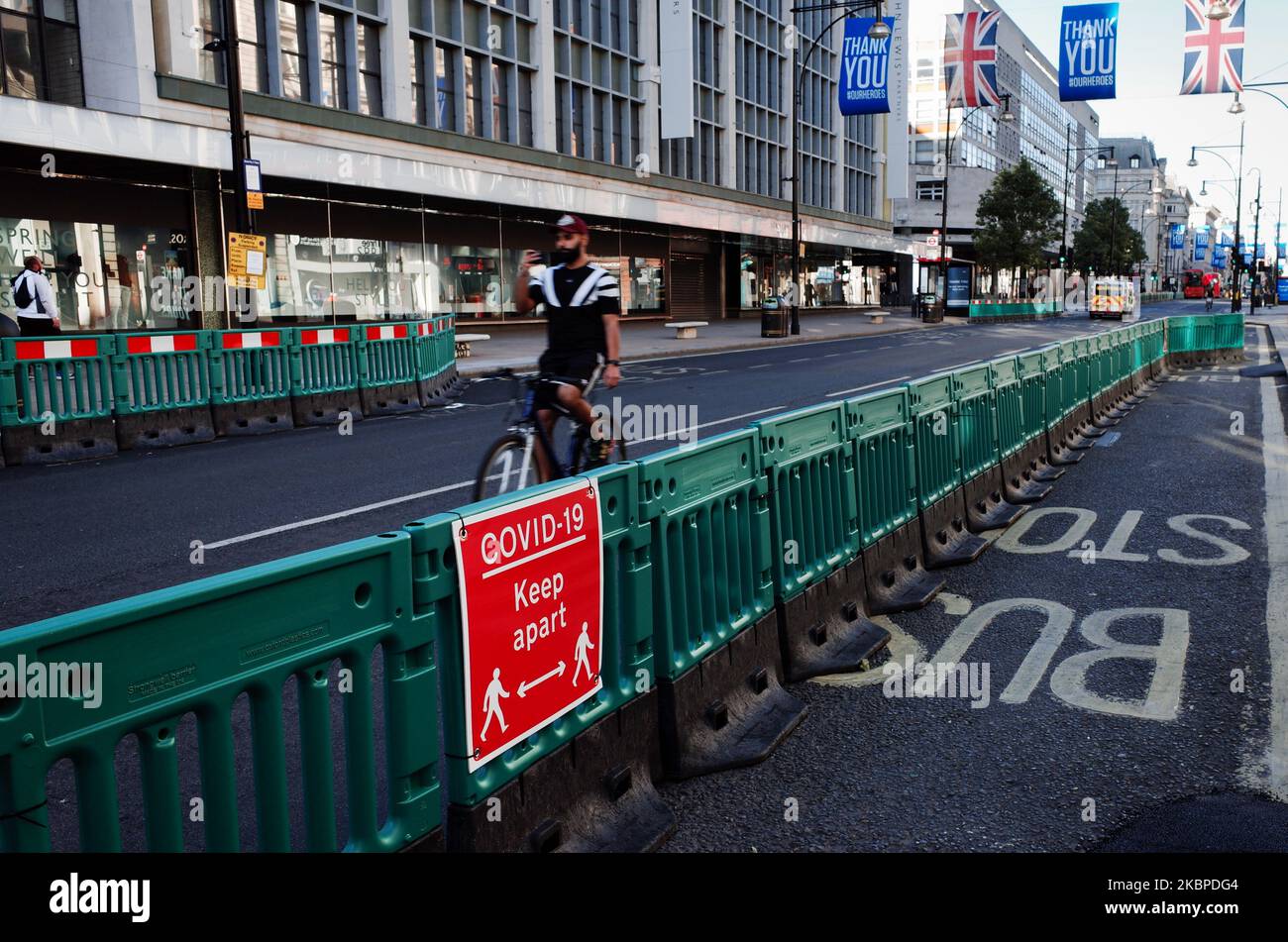 Ein Radfahrer fährt am 29. Mai 2020 an den Barrieren von Abschnitten verbreiterter Gehwege vorbei, die für zusätzliche Kapazität für Fußgänger ausgelegt sind, während die Richtlinien zur sozialen Distanzierung weiterhin in Kraft bleiben, auf einer fast menschenleeren Oxford Street in London, England. Das Vereinigte Königreich befindet sich jetzt in der zehnten Woche der Blockierung des Coronavirus, wobei die Gesamtzahl der Todesfälle nach einem positiven Covid-19-Test jetzt bei 38.161 liegt, laut der heutigen aktualisierten Zählung des Gesundheitsministeriums. In England sollen ab Montag eine Reihe von gelockerten Einschränkungen in Kraft treten, darunter die Erlaubnis für Gruppen von bis zu sechs Personen, sich im Freien zu treffen Stockfoto