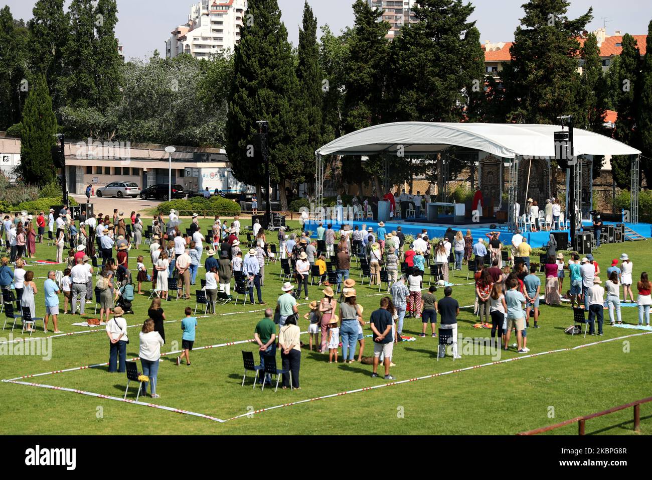 Faithfuls mit Gesichtsmasken beobachten soziale Distanzierungen, während sie an einer Open-Air-Messe teilnehmen, die von Pfarrer Nuno Coelho am 31. Mai 2020 im Hippodrom in Cascais, Portugal, inmitten der COVID-19-Pandemie gefeiert wird. Neue Regeln für die Gläubigen und Anpassungen der Kulte wurden von der katholischen Kirche angenommen, um die Kirchen wieder zu öffnen. (Foto von Pedro FiÃºza/NurPhoto) Stockfoto