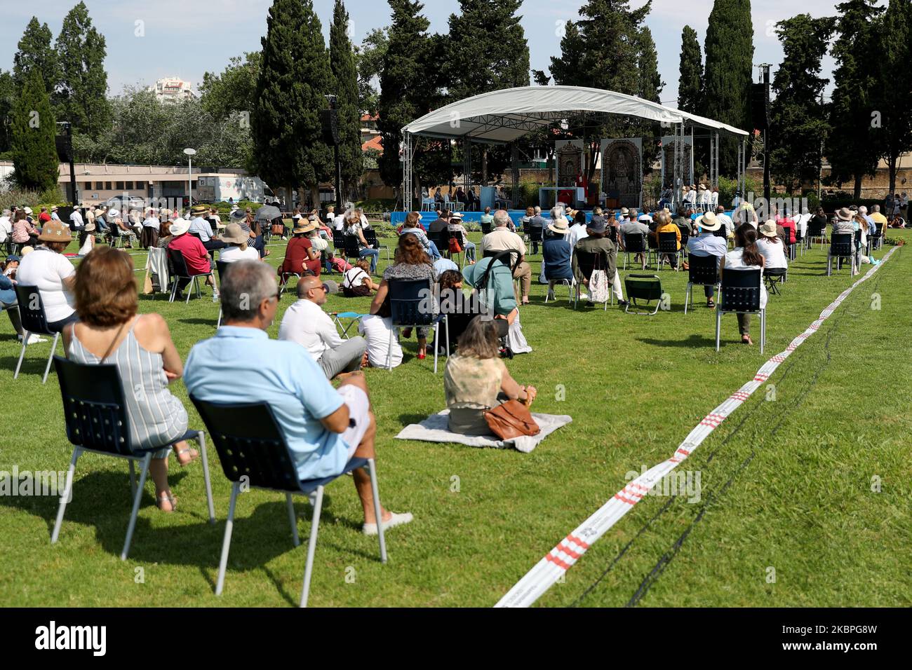 Faithfuls mit Gesichtsmasken beobachten soziale Distanzierungen, während sie an einer Open-Air-Messe teilnehmen, die von Pfarrer Nuno Coelho am 31. Mai 2020 im Hippodrom in Cascais, Portugal, inmitten der COVID-19-Pandemie gefeiert wird. Neue Regeln für die Gläubigen und Anpassungen der Kulte wurden von der katholischen Kirche angenommen, um die Kirchen wieder zu öffnen. (Foto von Pedro FiÃºza/NurPhoto) Stockfoto