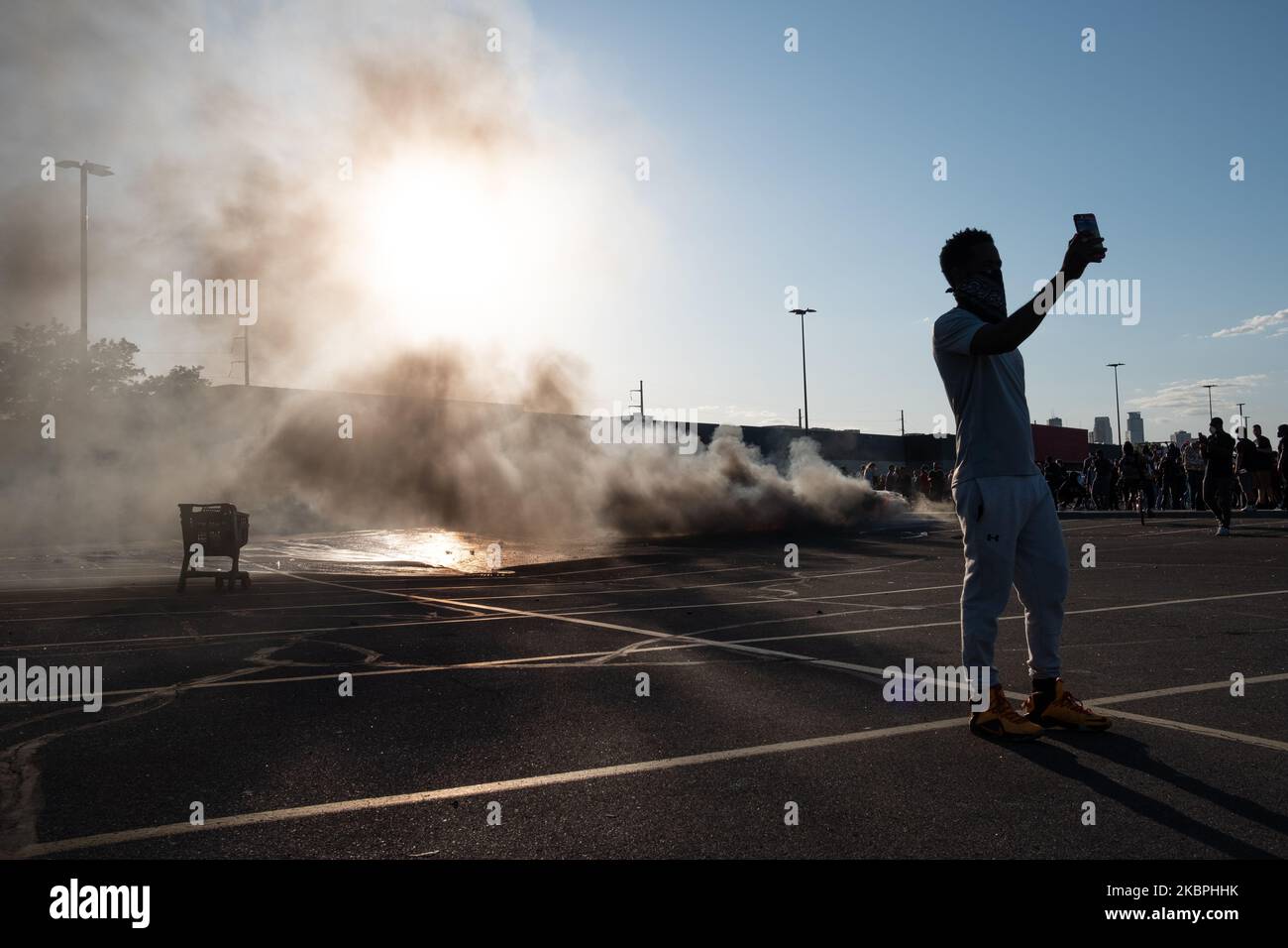 Ein Mann possiert für ein Selfie vor einem brennenden Fahrzeug in Minneapolis, MN, in Minneapolis, USA, am 28. Mai, 2020, während einer Demonstration, um Gerechtigkeit für George Floyd zu fordern, ein schwarzer Mann, der starb, während er in Gewahrsam der Minneapolis-Polizei war. Am Samstag wurden in großen Städten der USA Ausgangssperren verhängt, als die Auseinandersetzungen um die Brutalität der Polizei in ganz Amerika eskalierten. (Foto von Tim Evans/NurPhoto) Stockfoto