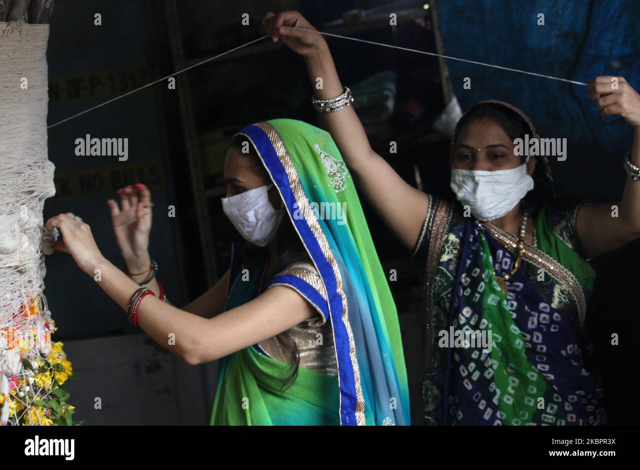 Anhänger mit Gesichtsmasken binden während des hinduistischen religiösen Festivals von Vata Savitri Purnima in Mumbai, Indien, am 05. Juni 2020 heilige Fäden um einen banyan-Baum. An diesem Tag beobachten verheiratete Frauen das Fasten und beten für das Wohlergehen ihrer Ehemänner. (Foto von Himanshu Bhatt/NurPhoto) Stockfoto