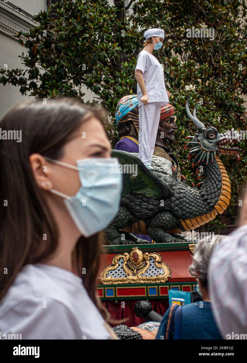 Eine Frau trägt eine Gesichtsmaske vor der La Tarasca-Schaufensterpuppe, die dieses Jahr aufgrund des Coronavirus in Granada, Spanien, am 10. Juni 2020, nicht zur Parade gehen konnte. Eine Mannequin, die im Volksmund als La Tarasca bekannt ist, nimmt die Straßen von Granada in Begleitung von Großkopfmännern in Verkleidung und Riesen auf. Es ist eine lokale Party, bei der ein Drache eine Schaufensterpuppe unterstützt, die von einem Modedesigner angezogen wird, der den Trend für die Kleidung setzt, die in diesem Sommer getragen werden soll. In diesem Jahr ist die Schaufensterpuppe als Gesundheitshelfer gekleidet, als Tribut an diejenigen, die hart gegen das Coronavirus gearbeitet haben. (Foto von Fermin Rodriguez/N Stockfoto