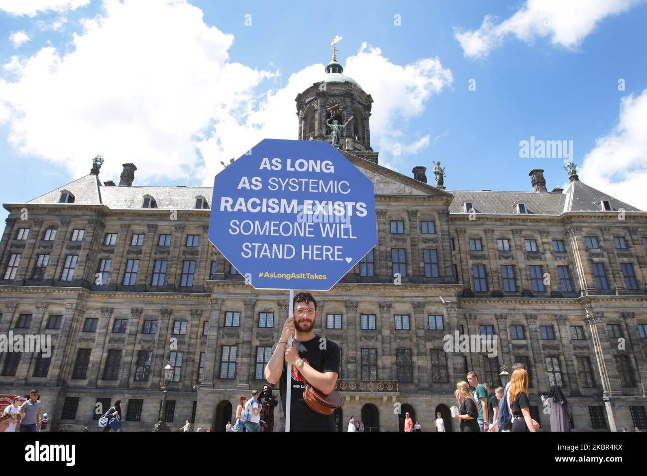 Ein Protestant hält ein Plakat mit dem Zeichen ‘solange systemischer Rassismus existiert, wird jemand hier stehen’ während einer Anti-Rassismus-Aktion vor dem Königlichen Palast am Dam-Platz inmitten der Coronavirus-Pandemie am 13. Juni 2020 in Amsterdam, Niederlande. Der Protest wurde von Mitgliedern der Zolanghetnodigis dazu aufgerufen, täglich auf dem Dam-Platz zu protestieren, bis, wie sie es nennen, systemischer Rassismus nicht mehr existiert. (Foto von Paulo Amorim/NurPhoto) Stockfoto