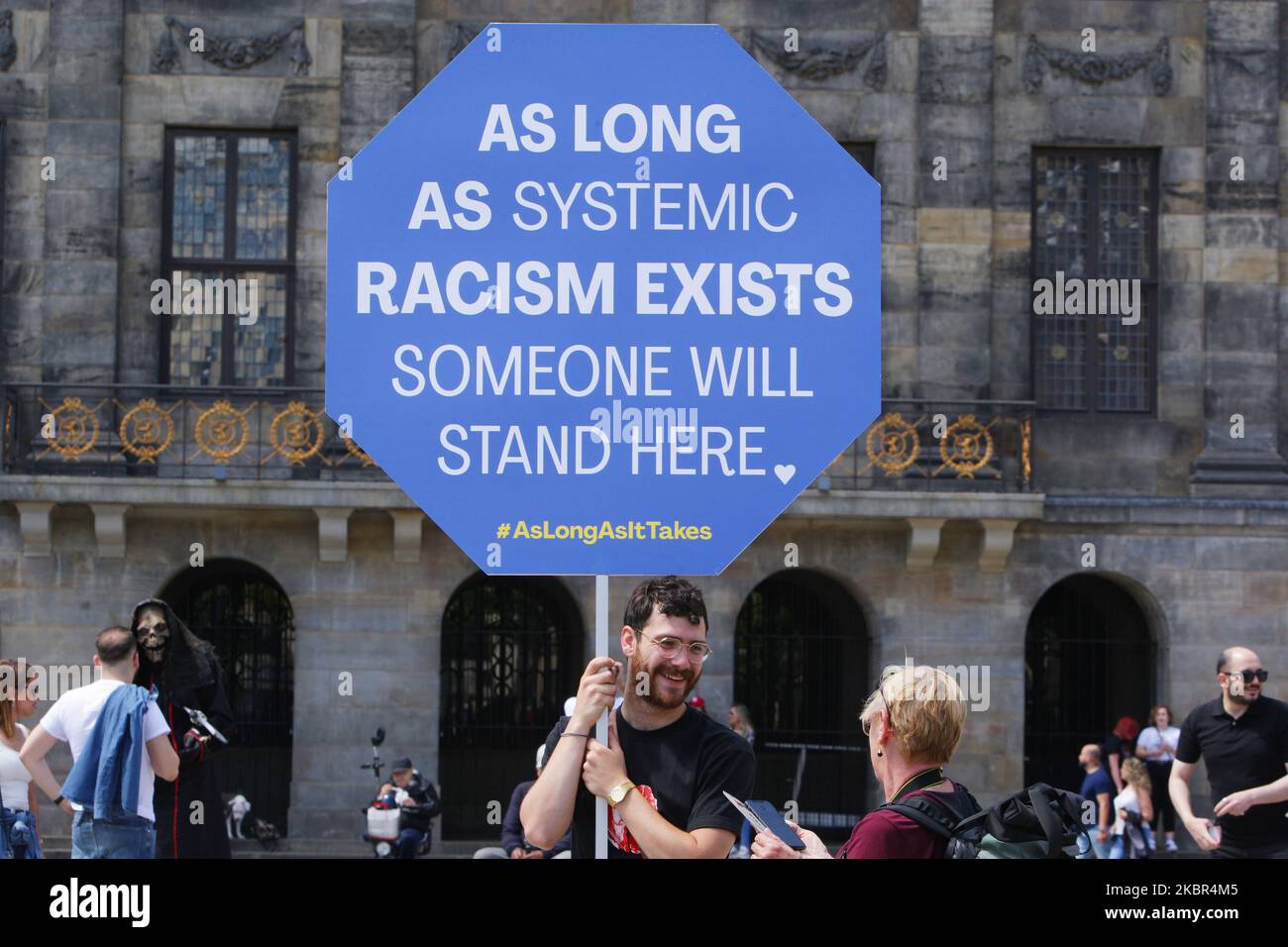 Ein Protestant hält ein Plakat mit dem Zeichen ‘solange systemischer Rassismus existiert, wird jemand hier stehen’ während einer Anti-Rassismus-Aktion vor dem Königlichen Palast am Dam-Platz inmitten der Coronavirus-Pandemie am 13. Juni 2020 in Amsterdam, Niederlande. Der Protest wurde von Mitgliedern der Zolanghetnodigis dazu aufgerufen, täglich auf dem Dam-Platz zu protestieren, bis, wie sie es nennen, systemischer Rassismus nicht mehr existiert. (Foto von Paulo Amorim/NurPhoto) Stockfoto