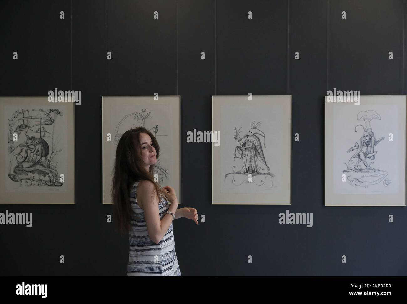 Ein Besucher ohne Gesichtsmaske sieht Lithographien des spanischen Künstlers Salvador Dali aus einer Privatsammlung aus Kiew bei einer Ausstellung zum Verkauf in einem städtischen Auktionshaus 'Golden Ratio' in Kiew, Ukraine, 13. Juni 2020. Trotz Quarantäne kamen Dutzende von Menschen, um sich 25 Lithographien anzusehen, die auf Gargantua und Pantagruel des französischen Schriftstellers Francois Rabelais aus dem 16. Jahrhundert basieren und menschliche Laster darstellen, die schätzungsweise für Tausende von US-Dollar versteigert werden. (Foto von Sergii Chartschenko/NurPhoto) Stockfoto