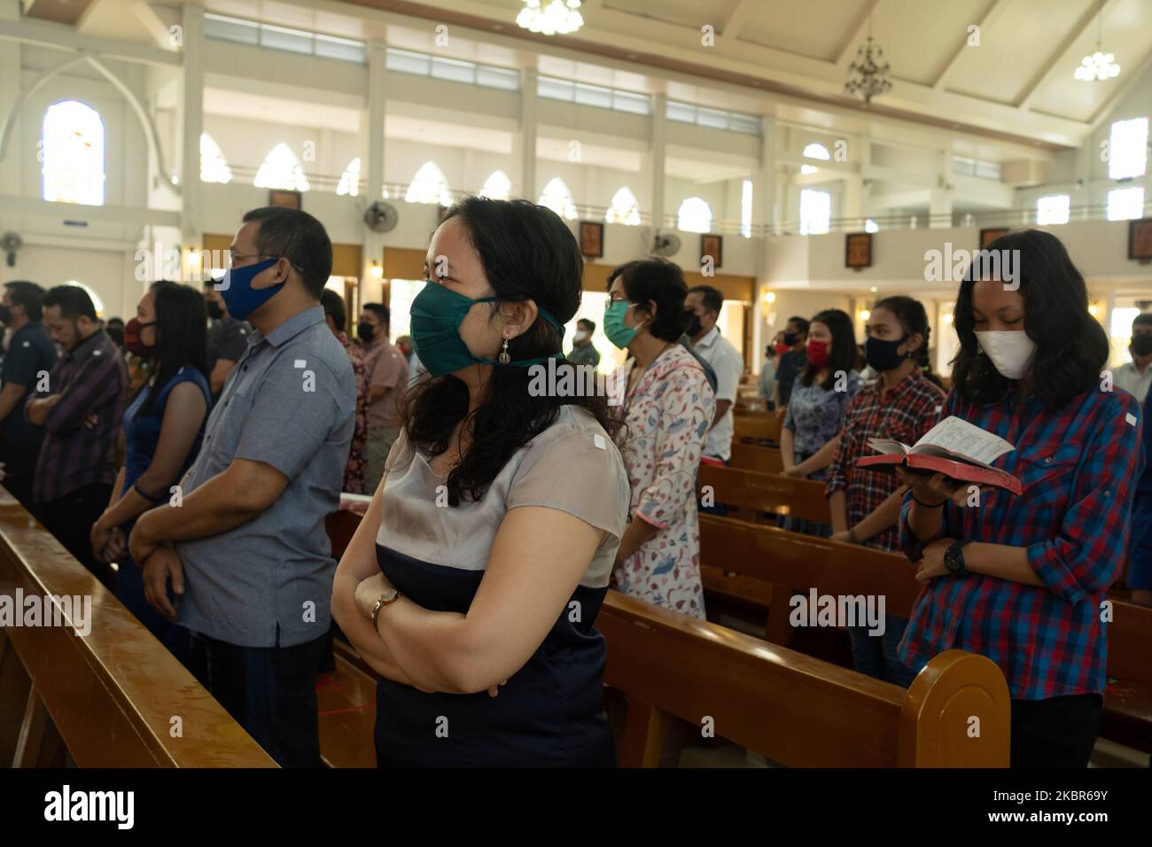 Menschen mit einer schützenden Gesichtsmaske sitzen auf den Kirchenbänken, die Mitglieder der Gemeinde dazu anmahnten, während eines Sonntagsgottesdienstes in der St. Paulus Kirche in Pekanbaru, Indonesien, am 10. Mai 2020 soziale Distanzierungen zu beobachten. Die indonesische Regierung hat eine neue Reihe von Vorschriften erlassen, die als „neue Normalität“ bekannt sind und schrittweise umgesetzt werden. (Foto von Afrianto Silalahi/NurPhoto) Stockfoto