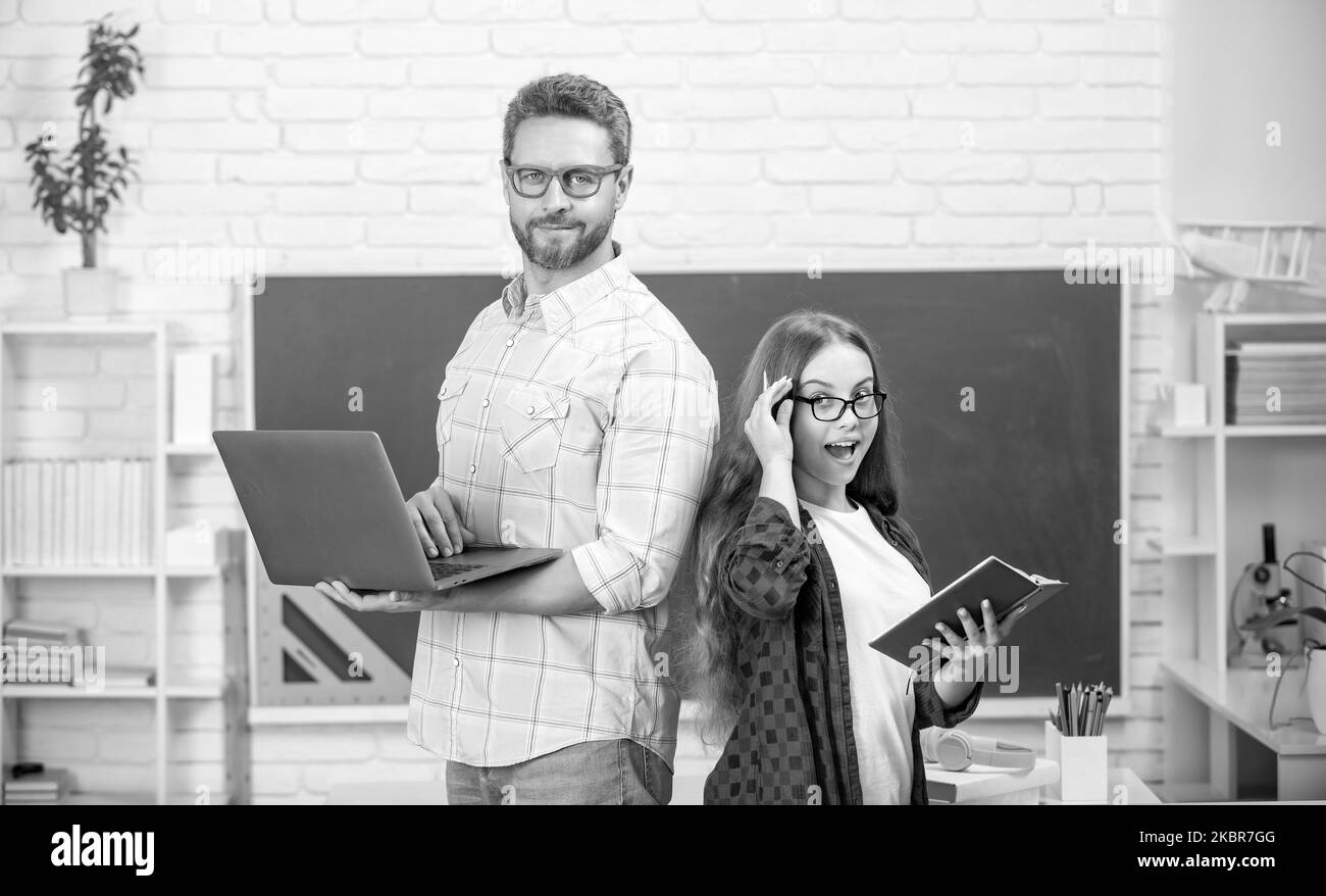 Stauned teen Mädchen und Lehrer Mann in der High School mit Arbeitsbuch an Tafel, Online-Unterricht Stockfoto