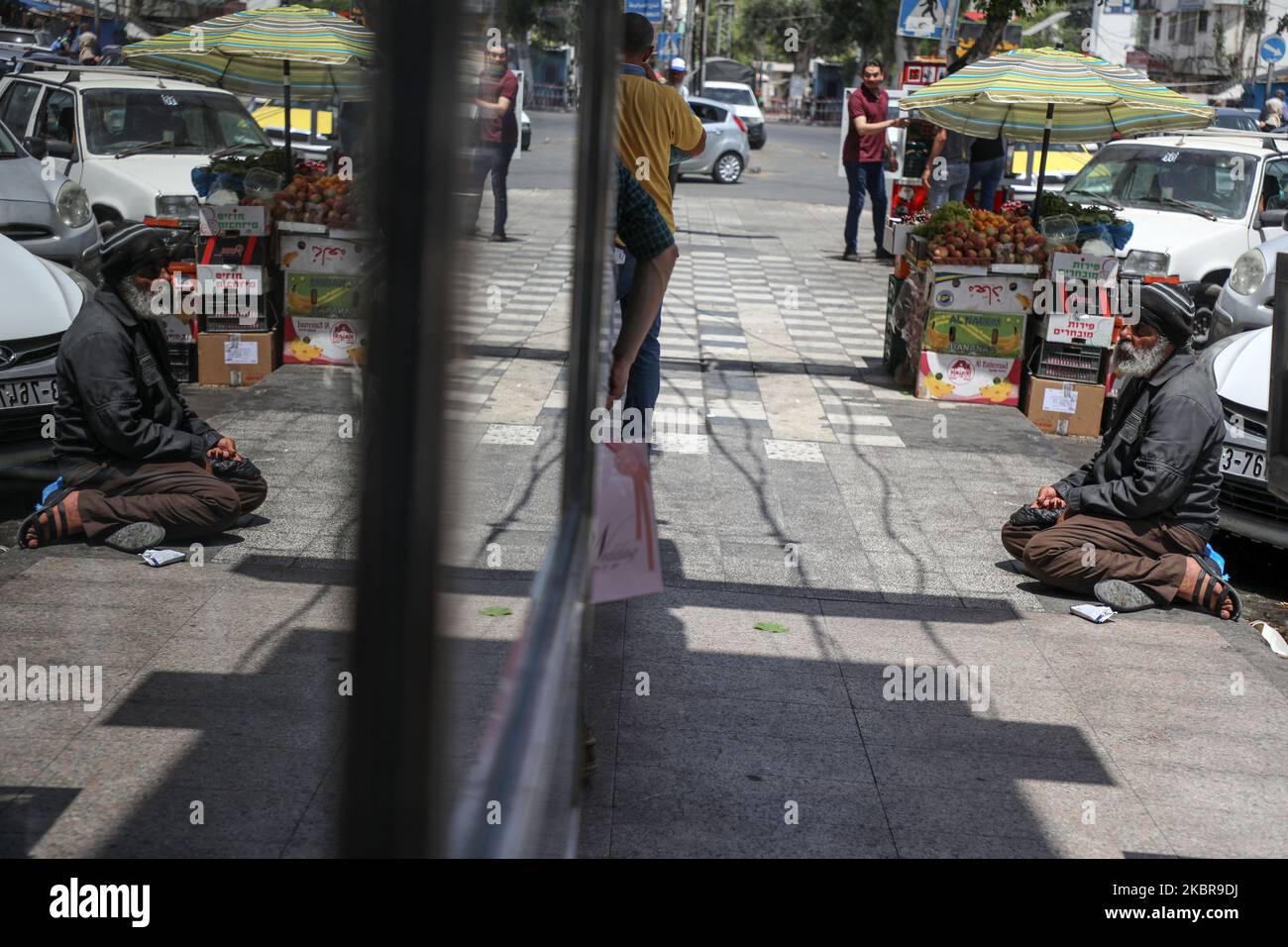 Während der anhaltenden Pandemiekrise des Coronavirus Covid-19 in Gaza City am 17. Juni 2020 sitzt ein Bettler auf dem Bürgersteig inmitten einer Hitzewelle. (Foto von Majdi Fathi/NurPhoto) Stockfoto