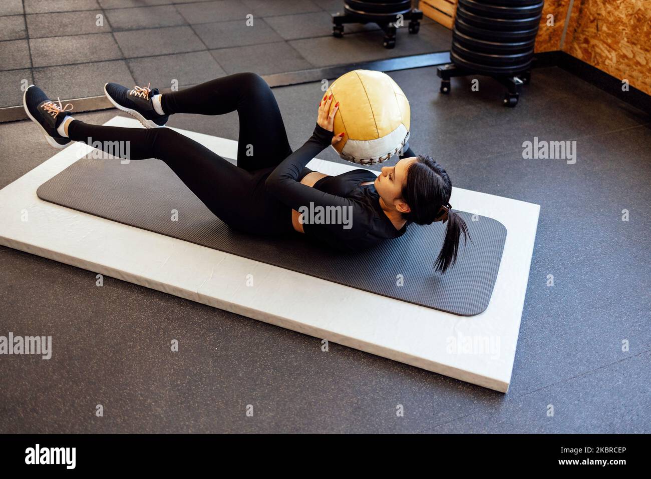 Athletische Brünette Mädchen trainieren in der Turnhalle. Fitness Frau Training mit Medizinball Stockfoto