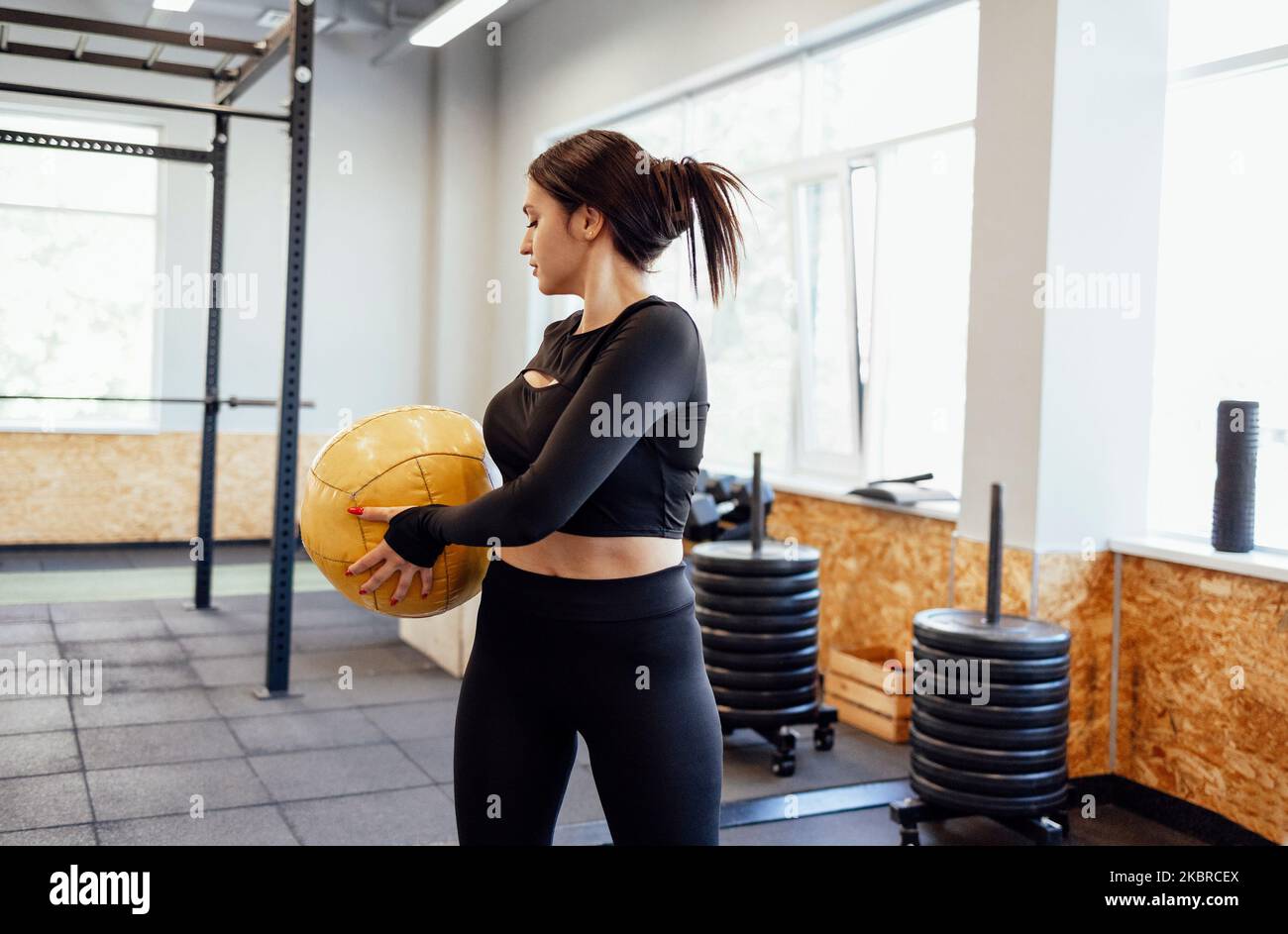 Athletische Brünette Mädchen trainieren in der Turnhalle. Fitness Frau Training mit Medizinball Stockfoto