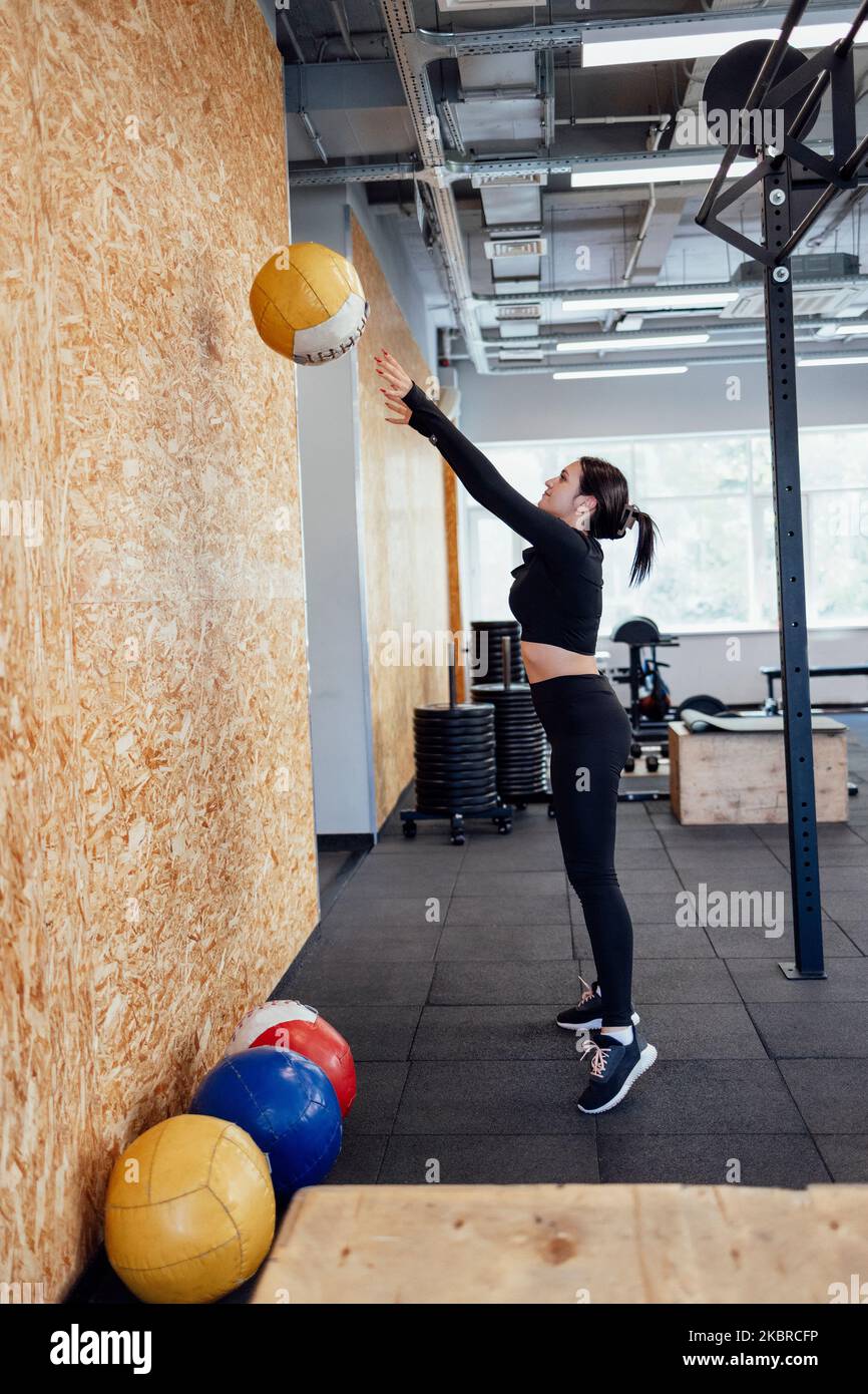 Athletische Brünette Mädchen trainieren in der Turnhalle. Fitness Frau Training mit Medizinball Stockfoto