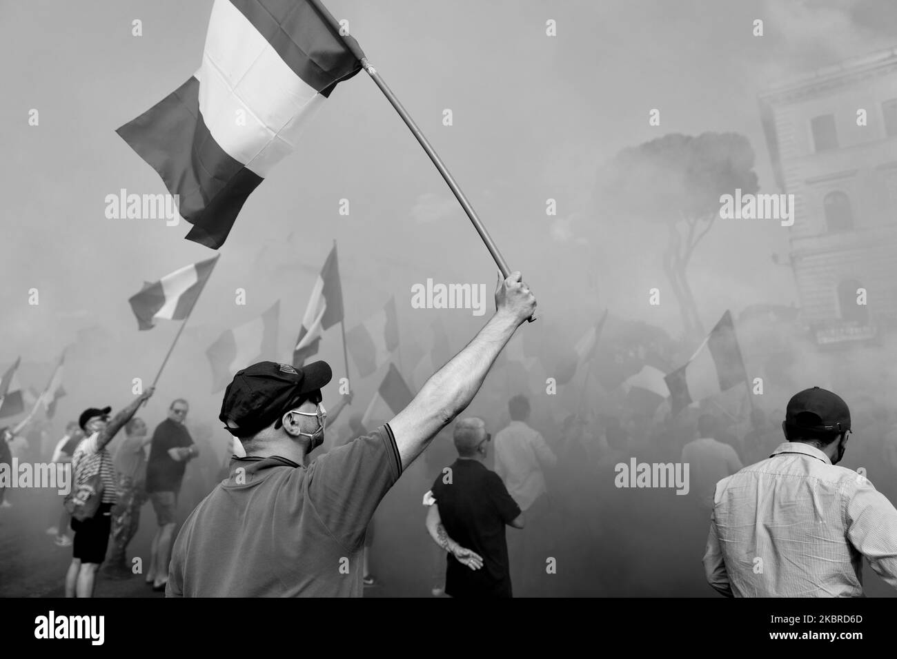 (ANMERKUNG DES HERAUSGEBERS: BILD WURDE IN SCHWARZ-WEISS umgewandelt) Ein Protestler trägt die italienische Flagge bei dem rechtsextremen Protest bei der ''Bocca della Verita''' in Roma-Forderung der ''Mascherine Tricolore''-Bewegung, gegen die italienische Regierung zu demostrieren. Die Bewegung ''Mascherine Tricolore'' entstand nach der Entscheidung der italienischen Regierung, die Nation nach der Ausbreitung von Covid-19 zu sperren. Die Bewegung protestiert gegen die Wirtschaftskrise, die durch die Aussperrung am 20.. Juni 2020 in Rom, Italien, verursacht wurde. (Foto von Matteo Trevisan/NurPhoto) Stockfoto