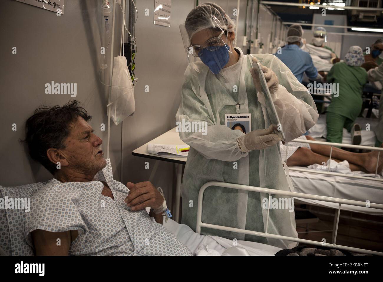 Ein Psichologe hilft einem Patienten, mit seiner Familie mit einem im Krankenhaus befindlichen Tablet zu sprechen, da persönliche Gegenstände im Pedro Dell'Antonia Campaign Hospital in Santo Andre, einem Teil der Metropolregion Sao Paulo, verboten sind, um sich in der dort gebauten Turnhalle ansteckend zu halten. Mehr als 4 Monate nach dem ersten gemeldeten Fall und 3 der offiziellen Quarantäne im Bundesstaat Sao Paulo kündigt die Regierung neue Öffnungsmaßnahmen an. Ab Juli 6. können Bar und Restaurants für Kunden geöffnet werden, während der Staat Aufzeichnungen über infizierte und Todesfälle aufgrund der neuen Coronavirus-Pandemie führt (Foto von Gustavo Bas Stockfoto