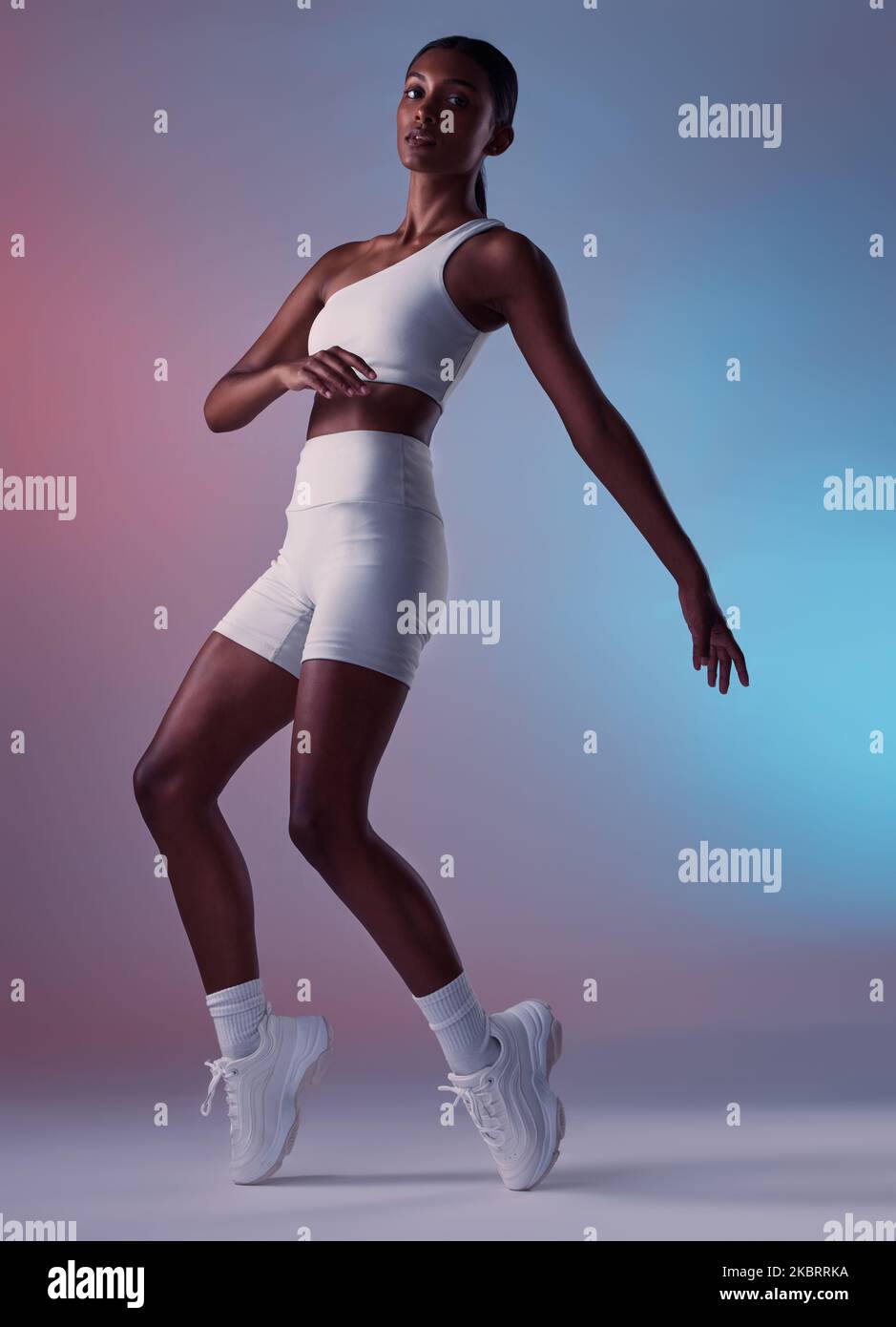 Gesundheit, Fitness und Sport Mode der Frau auf einem Studio Hintergrund bereit für das Training für Bewegung. Starke, sportliche und sportliche Bekleidung der Hündin mit einem Stockfoto