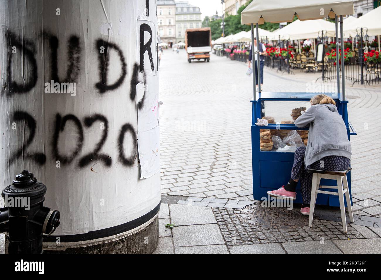 Der gelangweilte Verkäufer traditioneller Krakauer Bagels wird von einer Graffitti Duda 2020 während des Präsidentschaftswahlkampfs gesehen, da der derzeitige Präsident Polens Andrzej Duda am 3. Juli 2020 die Wiederwahl auf dem Hauptmarkt in der Altstadt von Krakau, Polen, anstrebt. Die zweite Runde der Präsidentschaftswahlen (die wegen des Coronavirus bereits verschoben wurde) ist für den 12. Juli geplant. Präsident Andrzej Duda und ein Oppositionskandidat Rafal Trzaskowski kamen in die Endrunde. (Foto von Dominika Zarzycka/NurPhoto) Stockfoto