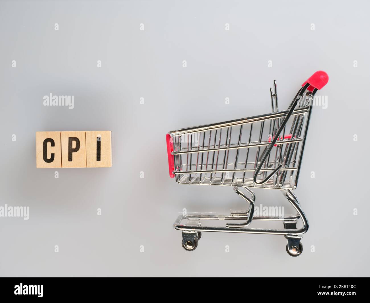 Supermarktwagen mit Holzblöcken mit Wort CPI auf weißem Hintergrund. Verbraucherpreisindex, Symbol des Verbraucherpreisindex Stockfoto
