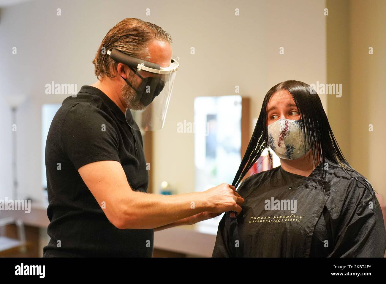 Conrad Blandford, Eigentümer des Conrad Blandford Friseursalons in Sheffield, trägt PPE (Personal Protective Equipment) und eine Gesichtsschutzmaske wirkt am 4. Juli 2020 in Sheffield, Großbritannien, mit dem die Friseursalons durch Lockdown wieder in ganz Großbritannien geöffnet werden können. Der Besitzer des Conrad Blandford Friseursalons hat seinen ersten Haarschnitt nach der Sperre versteigert und damit erstaunliche £180 erhöht, die im Rahmen der Geburtstagsfeier 72. an den NHS gespendet werden. Pubs, Restaurants, Friseursalons, Theater, Museen und Galerien werden am 4.. Juli nach einer landesweiten Sperre gegen die Ausbreitung der wieder eröffnet Stockfoto