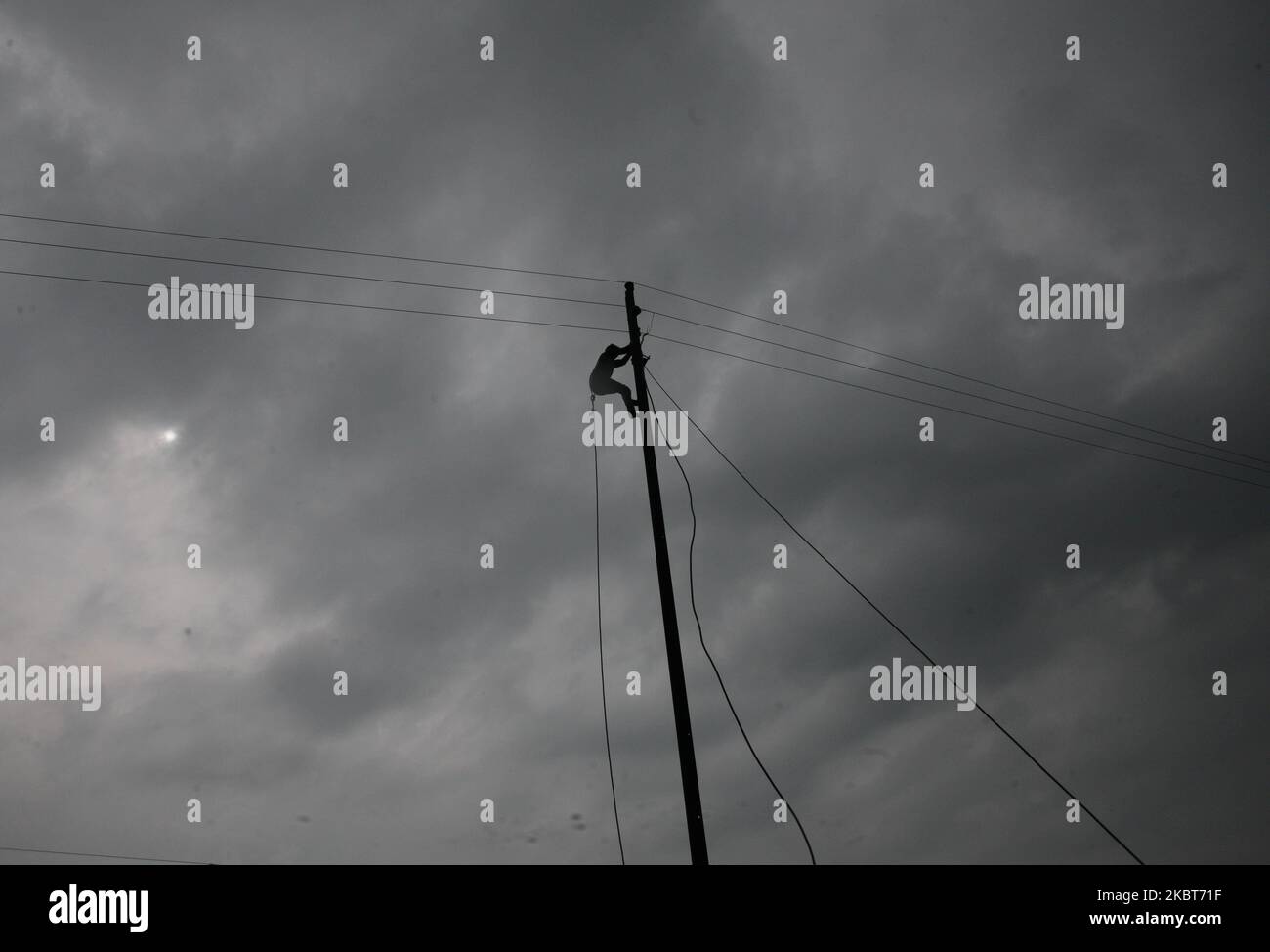 Ein Elektriker repariert elektrische Drähte auf einer Umfrage bei Regen , in den Außenbezirken von Allahabad am 7. Juli 2020 . (Foto von Ritesh Shukla/NurPhoto) Stockfoto