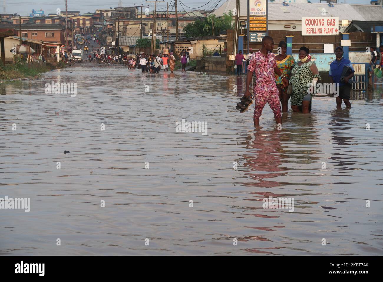 Die Bewohner waten durch die überflutete IgE Road, Aboru, Lagos. Die Überschwemmung störte die Bewegung und die sozioökonomischen Aktivitäten im Alabede-Gebiet der IgE Road, Aboru, Lagos, Nigeria, nach einem heftigen Regenguss am 6. Juli 2020. (Foto von Adekunle Ajayi/NurPhoto) Stockfoto