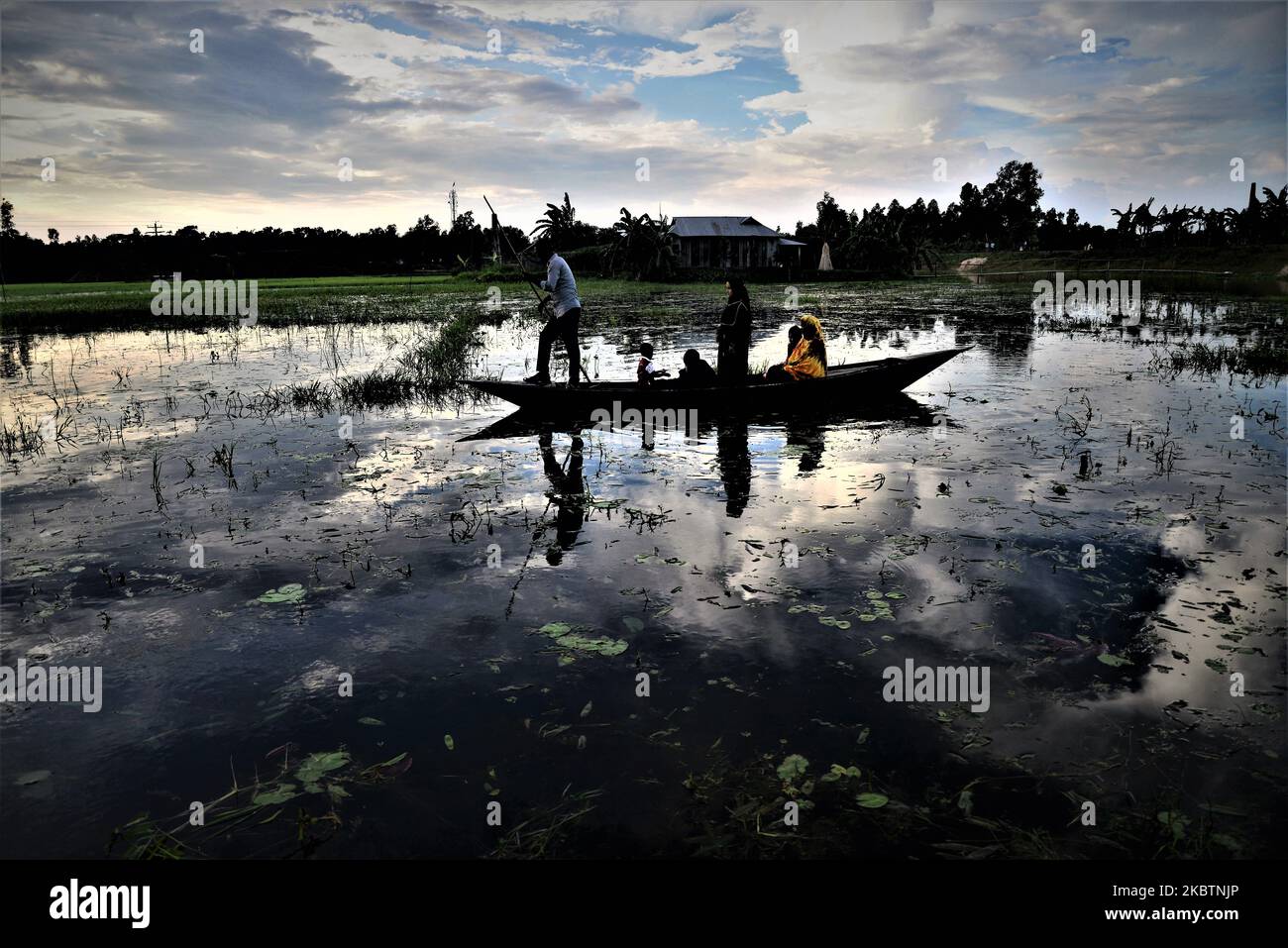 Dorfbewohner aus Bangladesch überqueren am 16. Juli 2020 auf dem Weg nach Hause im Distrikt Jamalpur, Bangladesch, das Flutwasser in einem Boot (Foto: Mamunur Rashid/NurPhoto) Stockfoto
