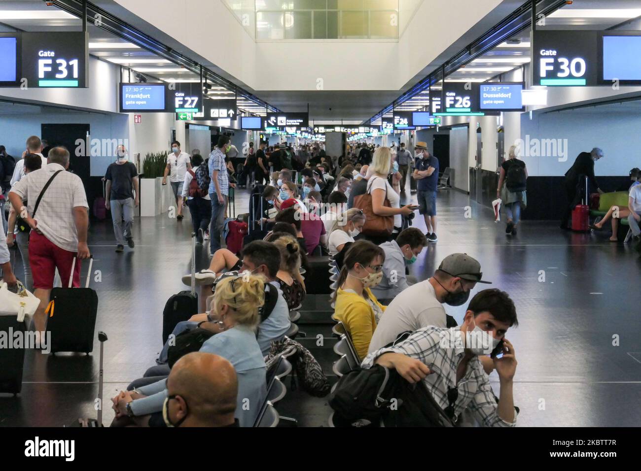 Passagiere, die Gesichtsmasken, Handschuhe und Sicherheitsmaßnahmen tragen, werden am 15. Juli 2020 im Terminal zu sehen sein. F Gates Area of Vienna International Airport VIE LOWW - Flughafen Wien-Schwechat dient der österreichischen Hauptstadt, aber auch Bratislava, wie es 55km entfernt von der slowakischen Stadt während der Covid-19 Coronavirus Pandemie Ära mit sozialen Distanzierungsmaßnahmen und Desinfektion von Hand Desinfektionsmittel überall nach der Sperrzeit ist. Am 1. Juli gibt Österreich eine Reisewarnung für sechs Balkanstaaten aus: Serbien, Montenegro, Bosnien-Herzegowina, Nord-Mazedonien, Albanien und Kosovo. Passagiere, die von diesen aus reisen Stockfoto