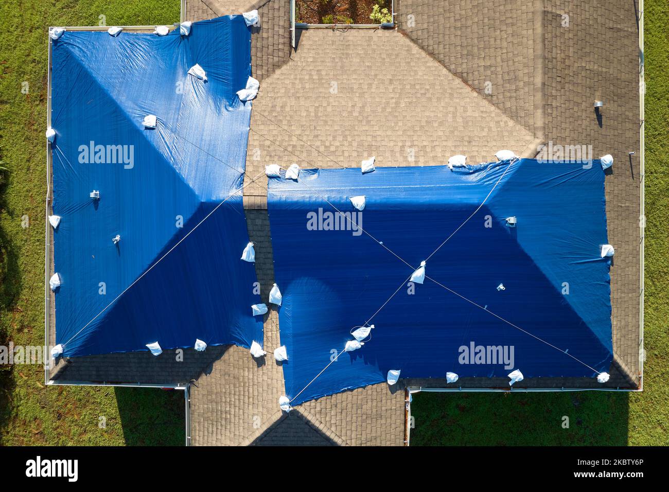 Luftaufnahme des beschädigten Hausdachs von Hurrikan Ian, das mit einer blauen Schutzplane gegen austretendes Regenwasser bedeckt ist, bis die Asphaltschindeln ersetzt wurden Stockfoto
