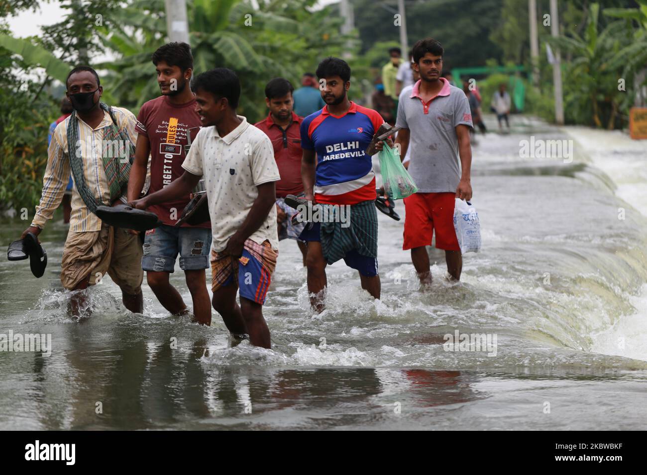 Am 28. Juli 2020 laufen Menschen in Dohar bei Dhaka, Bangladesch, durch das Hochwasser. (Foto von Rehman Asad/NurPhoto) Stockfoto