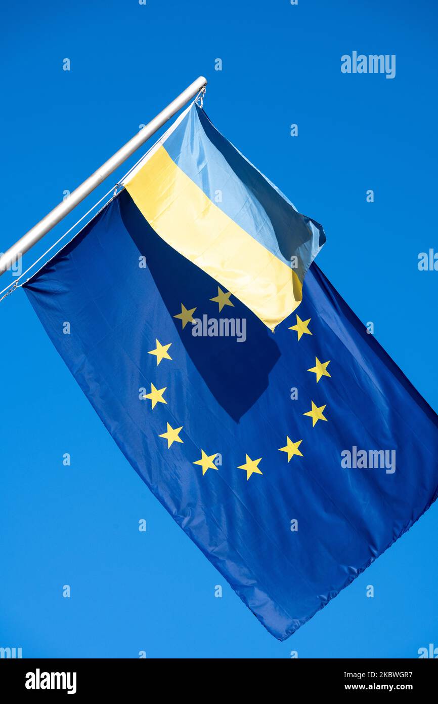 Die EU-Flagge zusammen mit einer ukrainischen Flagge vor einem blauen Himmel Stockfoto