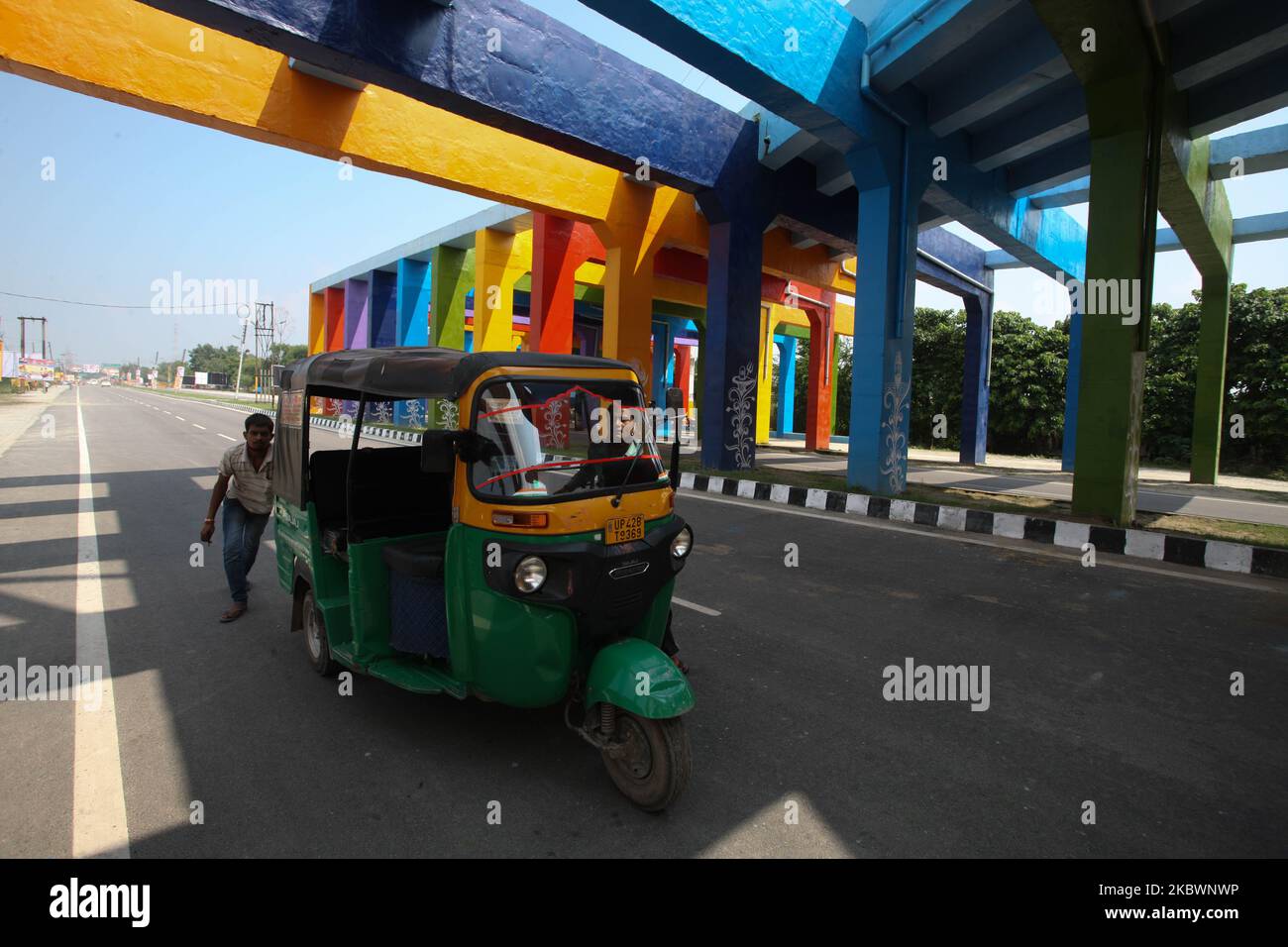 Ein Autorikscha-Fahrer schiebt seine Auto-Rikscha am 4. August 2020 in Ayodhya, Indien, unter eine geschmückte Straße, die vor der Ankunft des Premierministers Narendra Modi für die Eröffnungszeremonie des RAM Temple während der Pandemie von Covid 19 gemalt wurde. (Foto von Ritesh Shukla/NurPhoto) Stockfoto